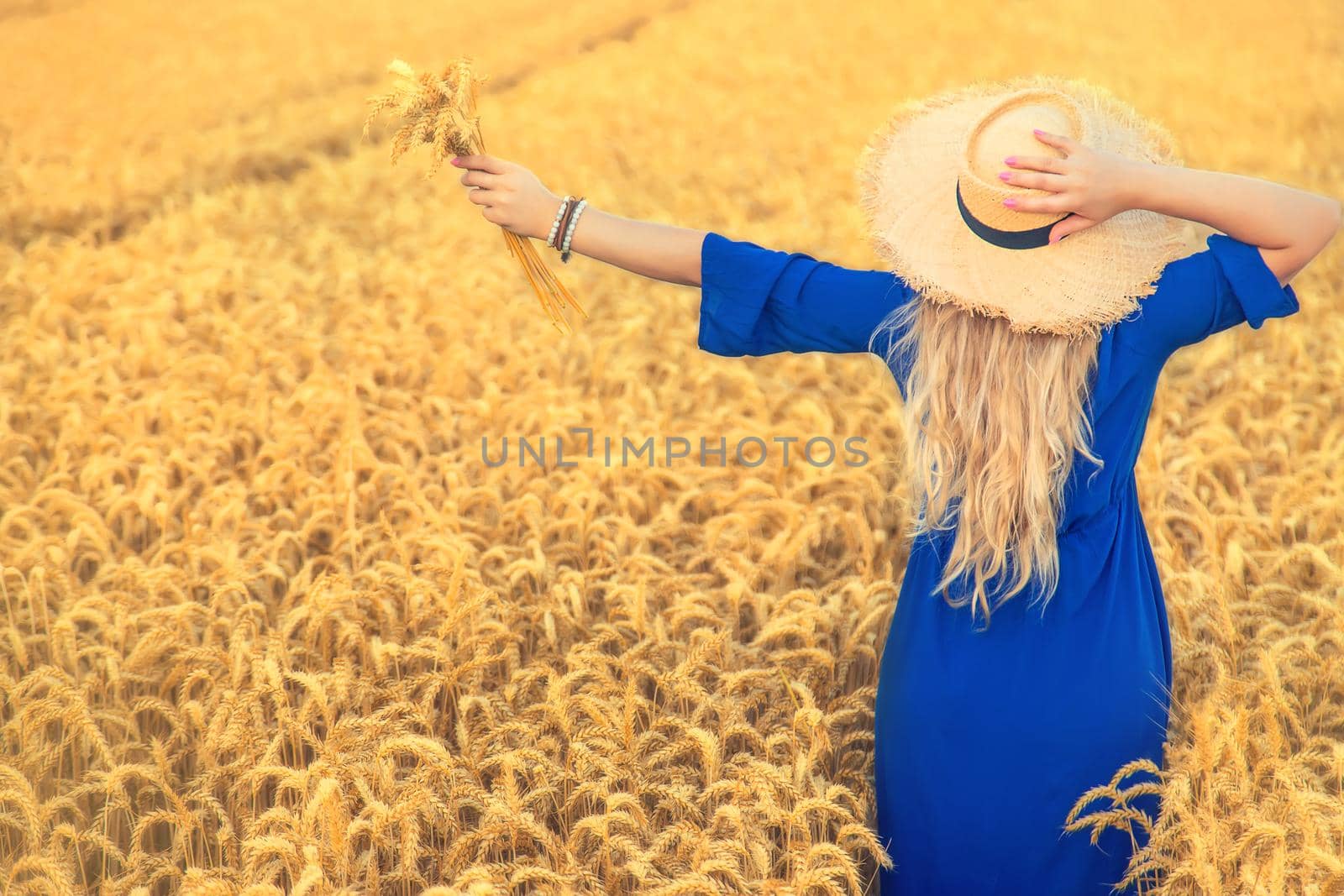 Woman in a wheat field. Selective focus. by yanadjana
