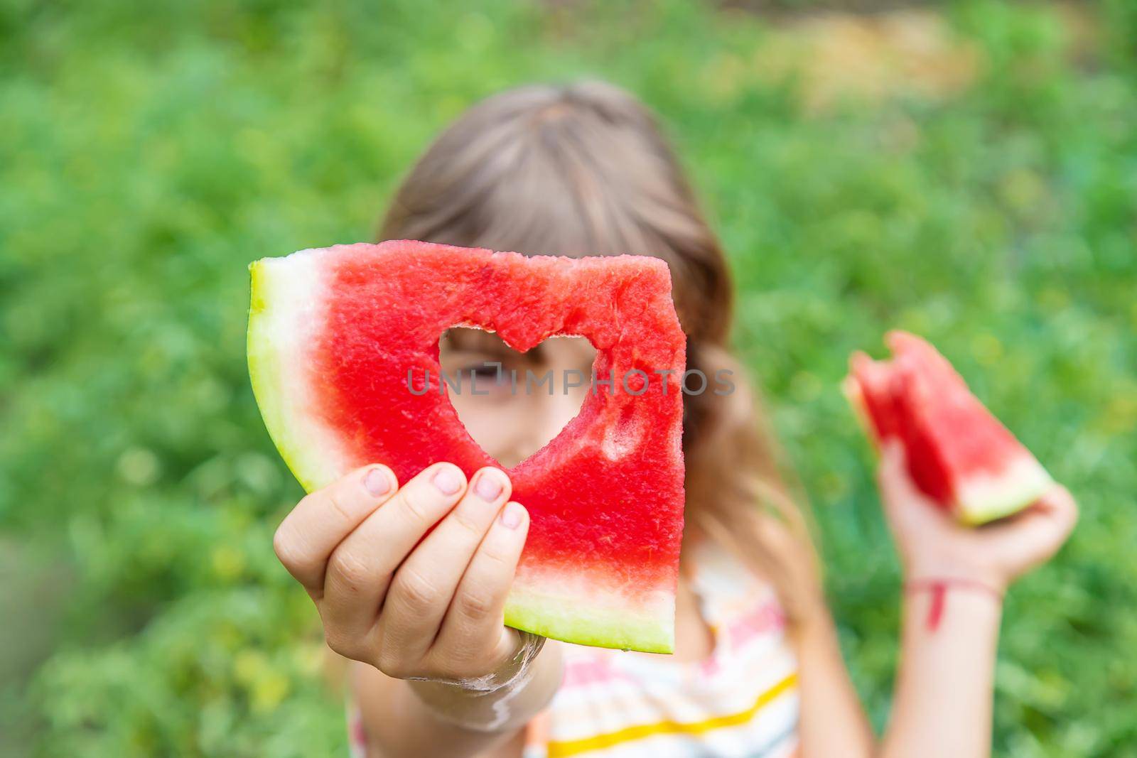 A child on a picnic eats a watermelon. Selective focus. Food.