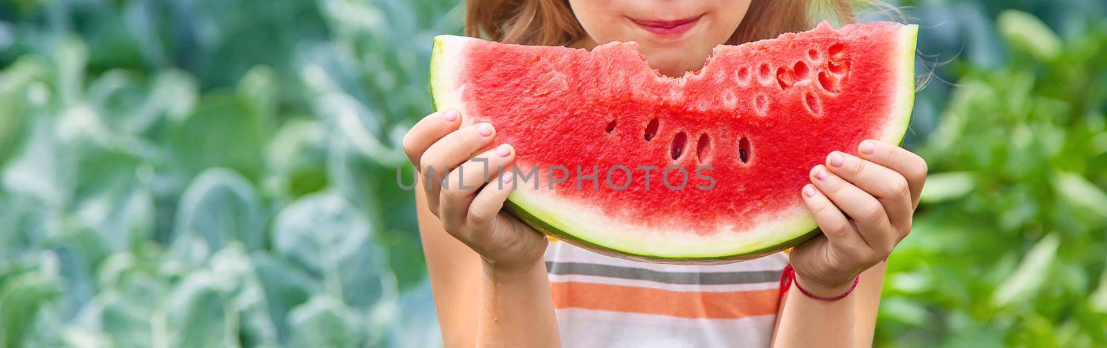 A child on a picnic eats a watermelon. Selective focus. food.