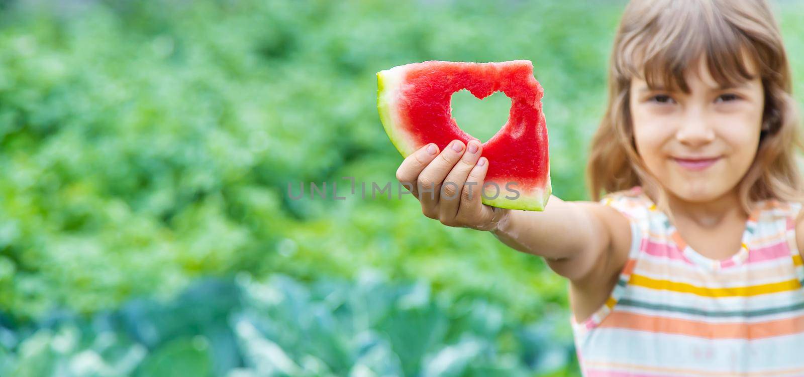 A child on a picnic eats a watermelon. Selective focus. Food.