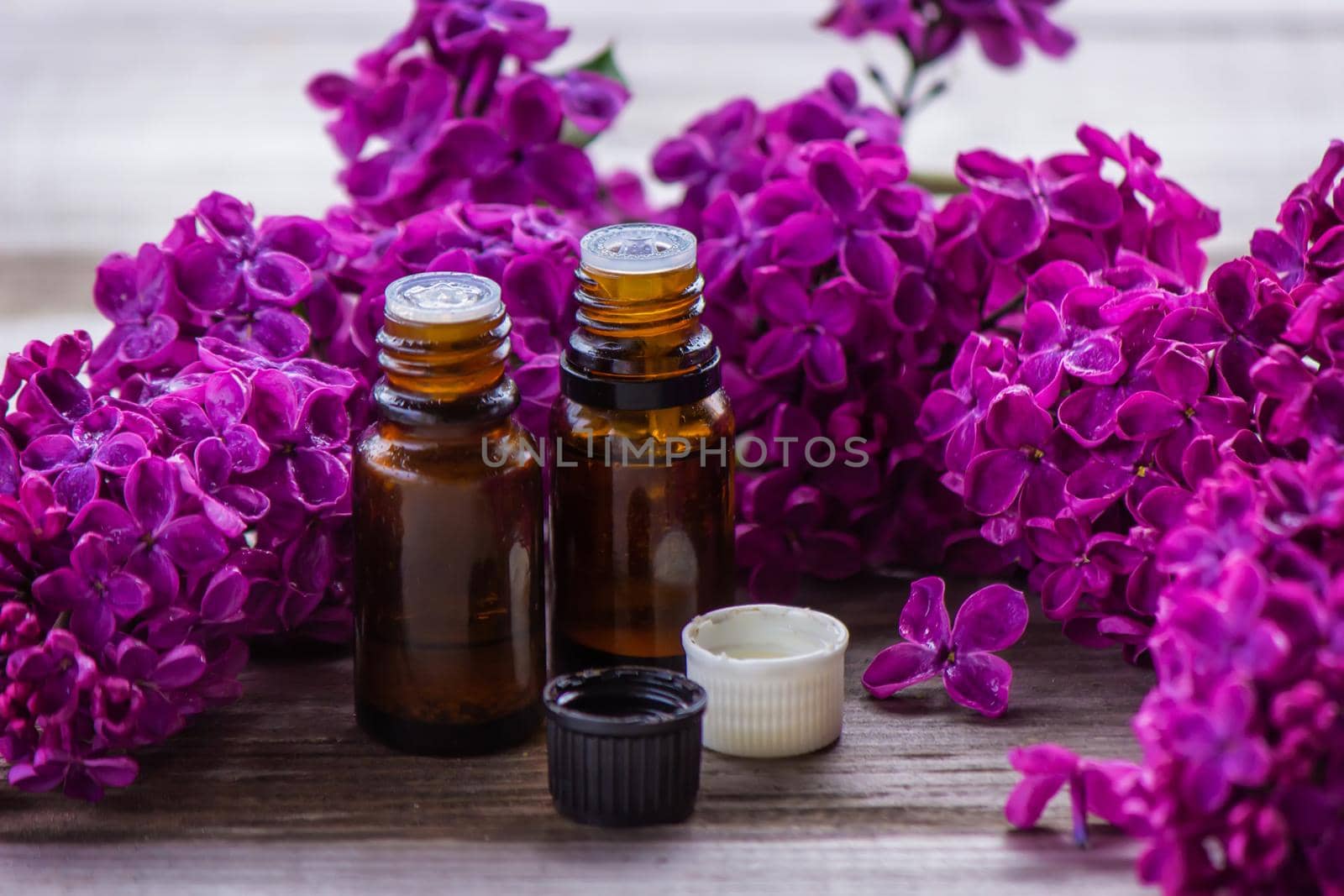 Lilac essential oil in a small bottle. Selective focus. Nature.