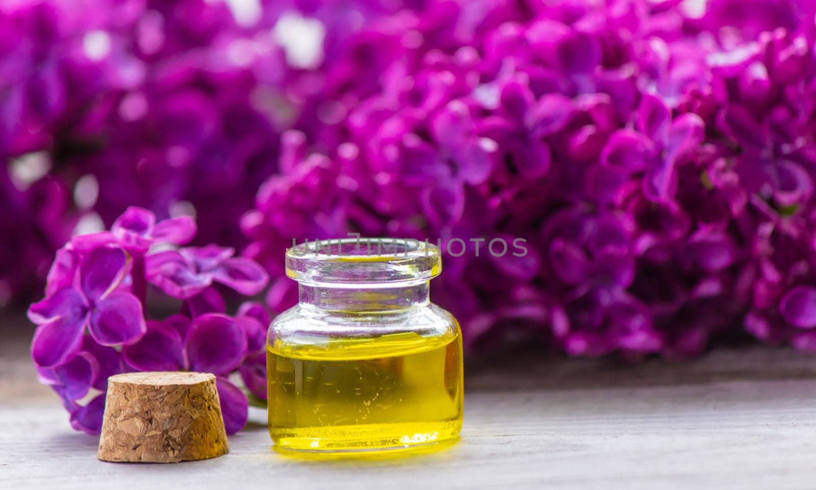 Lilac essential oil in a small bottle. Selective focus. Nature.