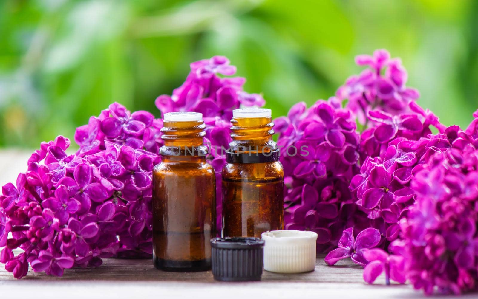 Lilac essential oil in a small bottle. Selective focus. Nature.