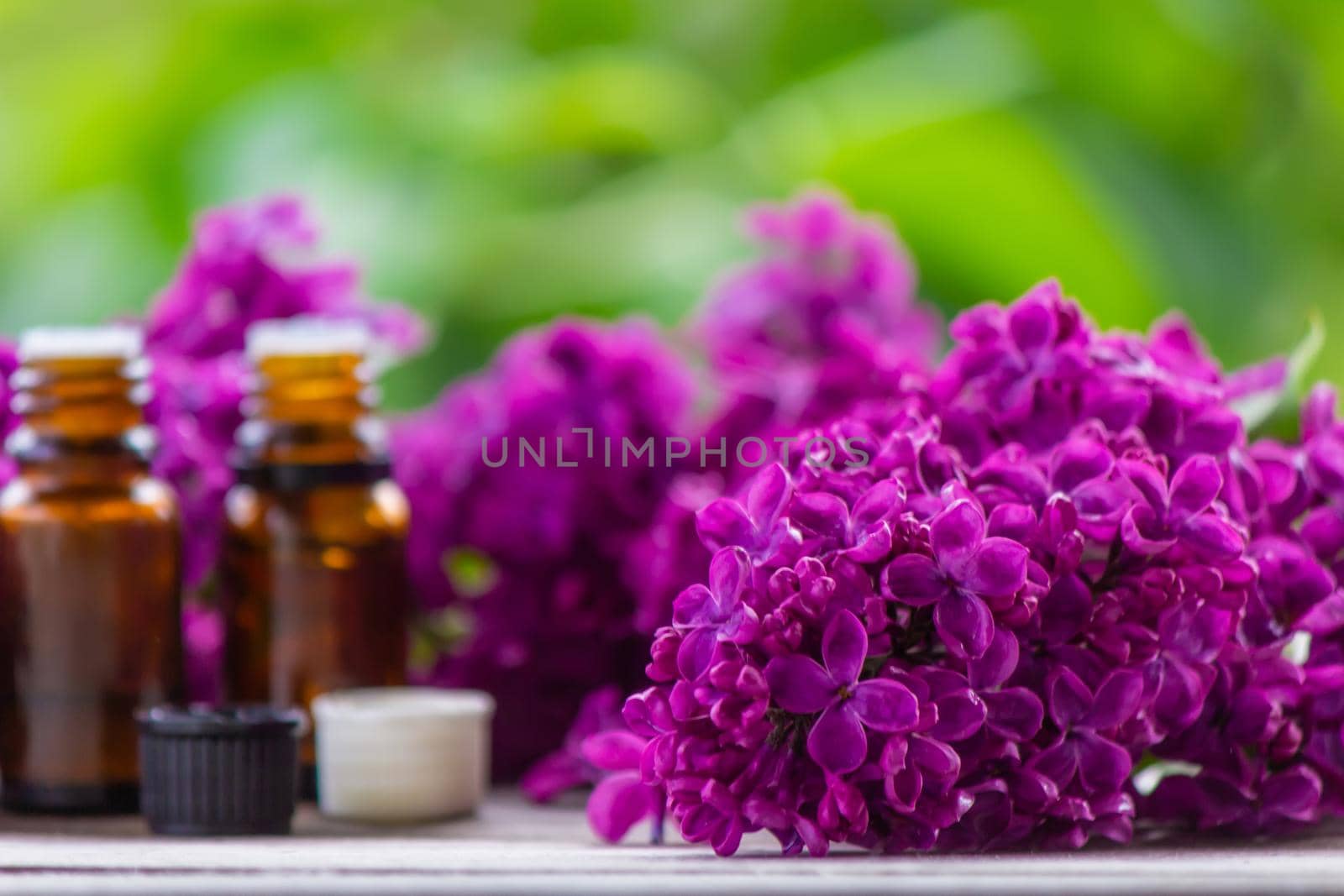 Lilac essential oil in a small bottle. Selective focus. Nature.