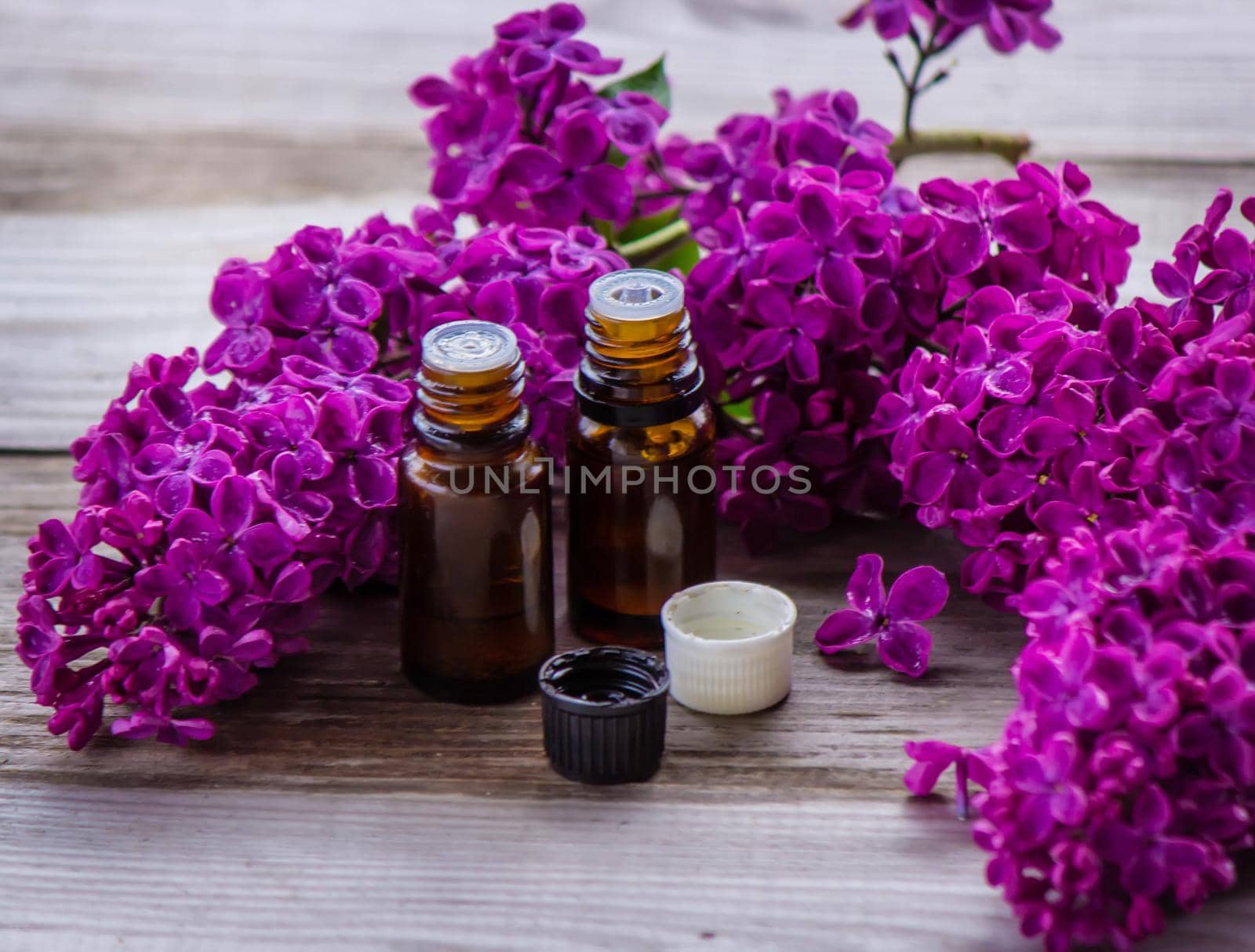 Lilac essential oil in a small bottle. Selective focus. Nature.