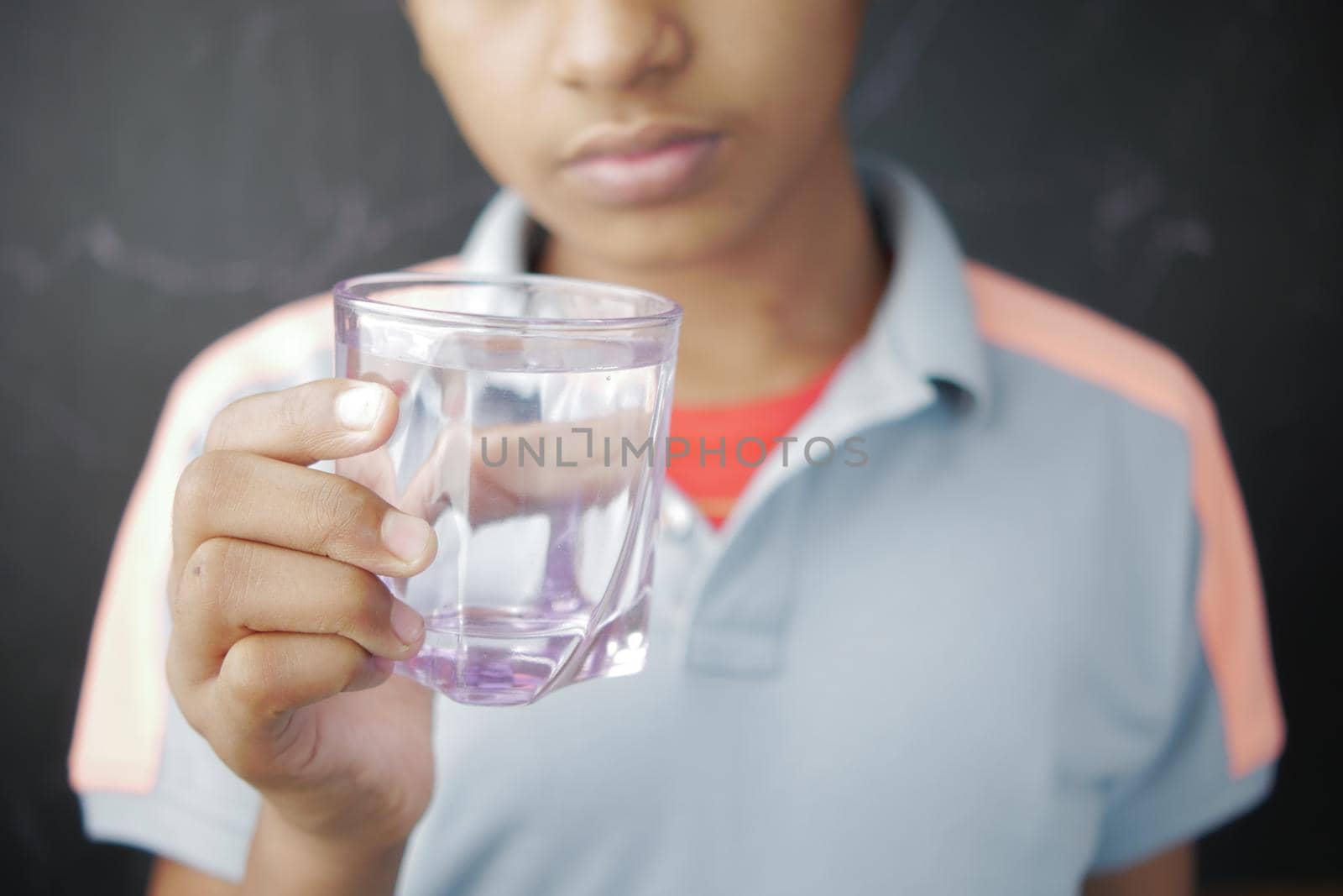 teenage boy drinking glass of water selective focus ,