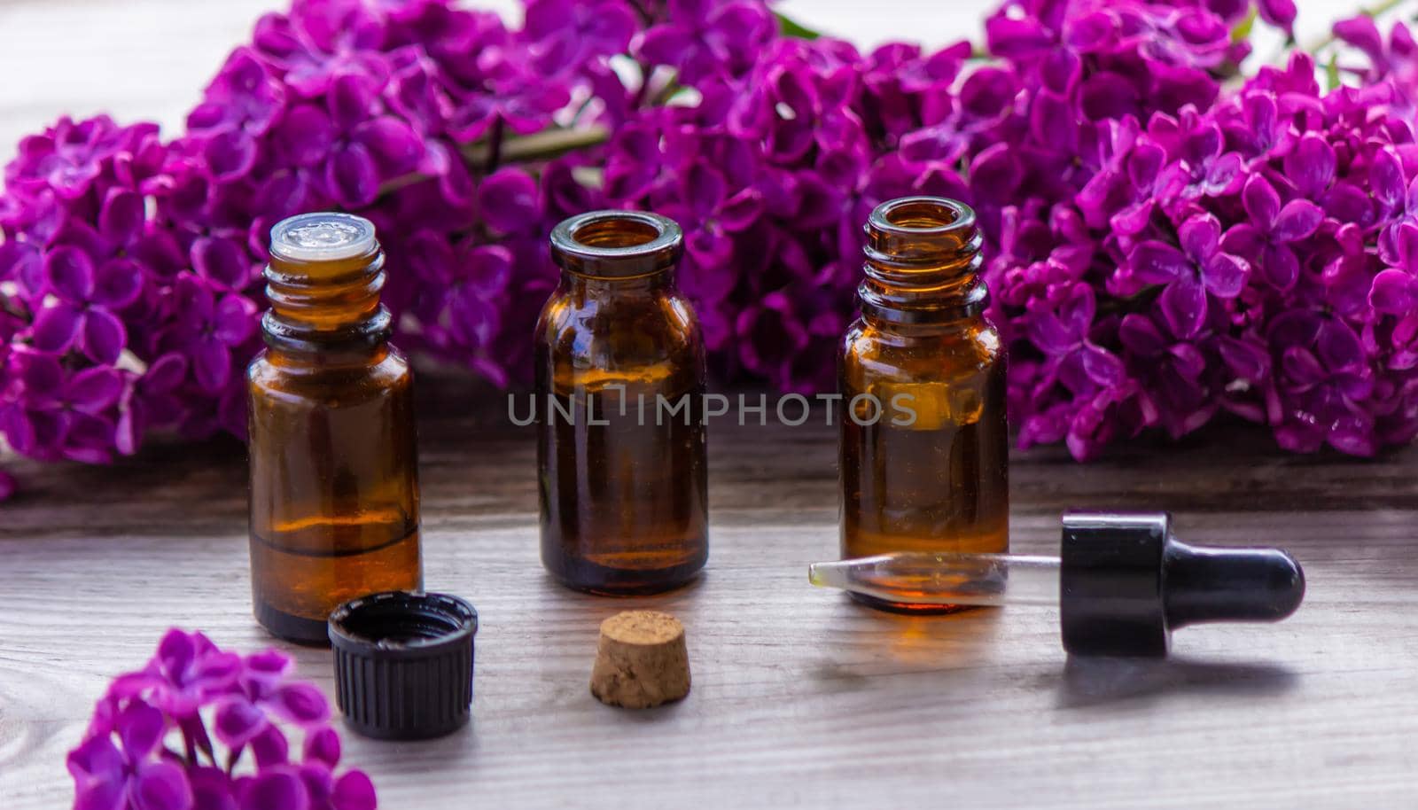 Lilac essential oil in a small bottle. Selective focus. Nature.