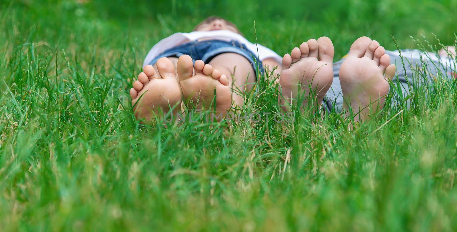 Children's feet on the green grass in the park. Selective focus. nature.