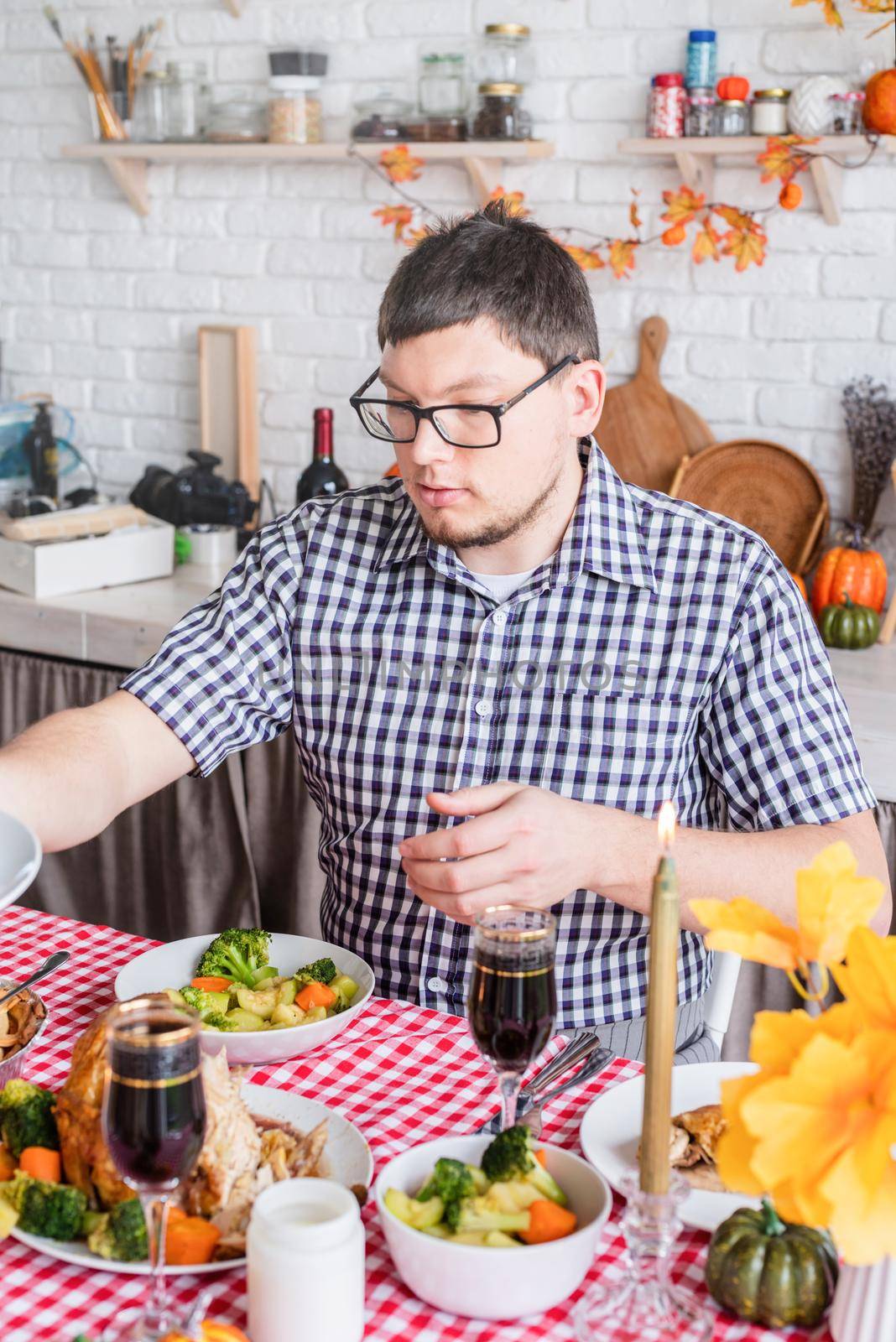 Happy Thanksgiving Day. Autumn feast. Woman and man celebrating holiday eating traditional dinner at kitchen with turkey, vegetables and pumpkin pie