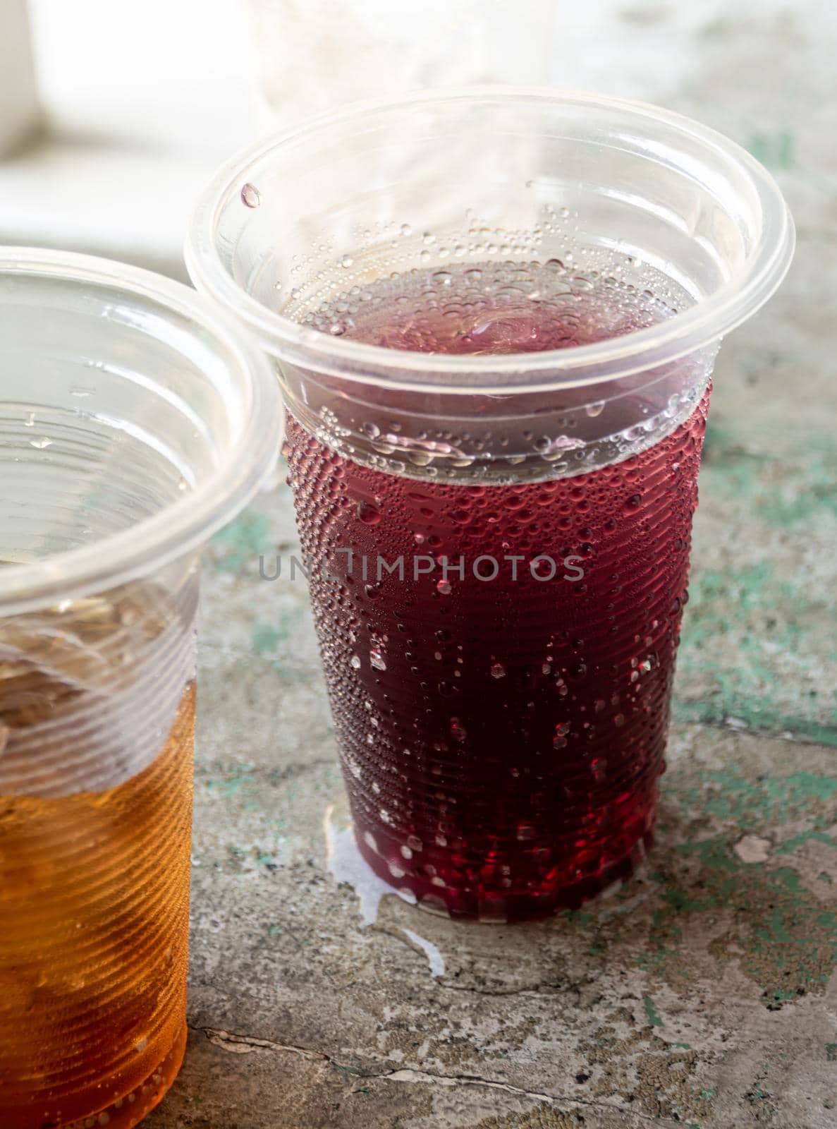 Soft drink and ice in the disposable plastic glasses by Satakorn