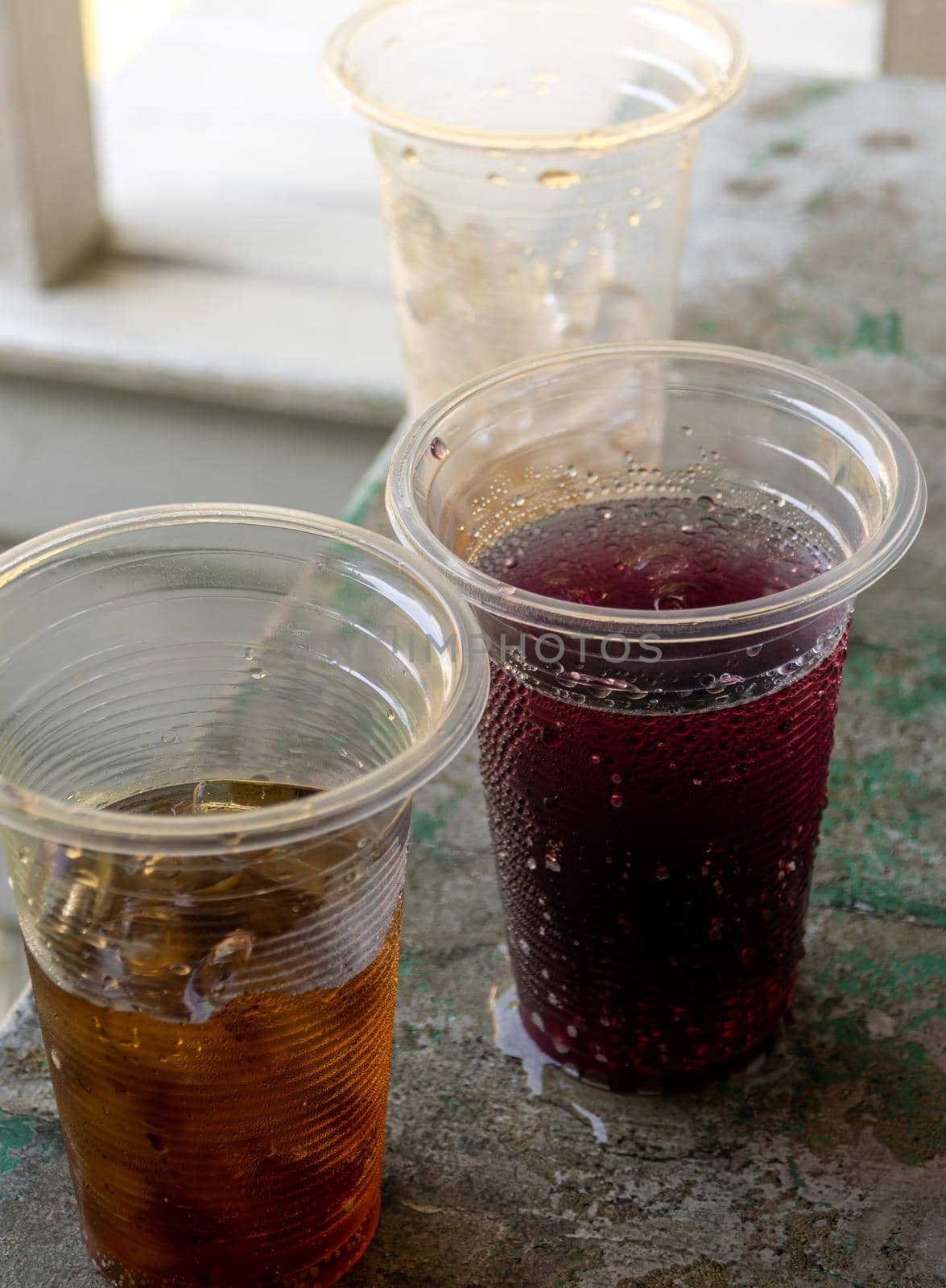 Soft drink and ice in the disposable plastic glasses by Satakorn