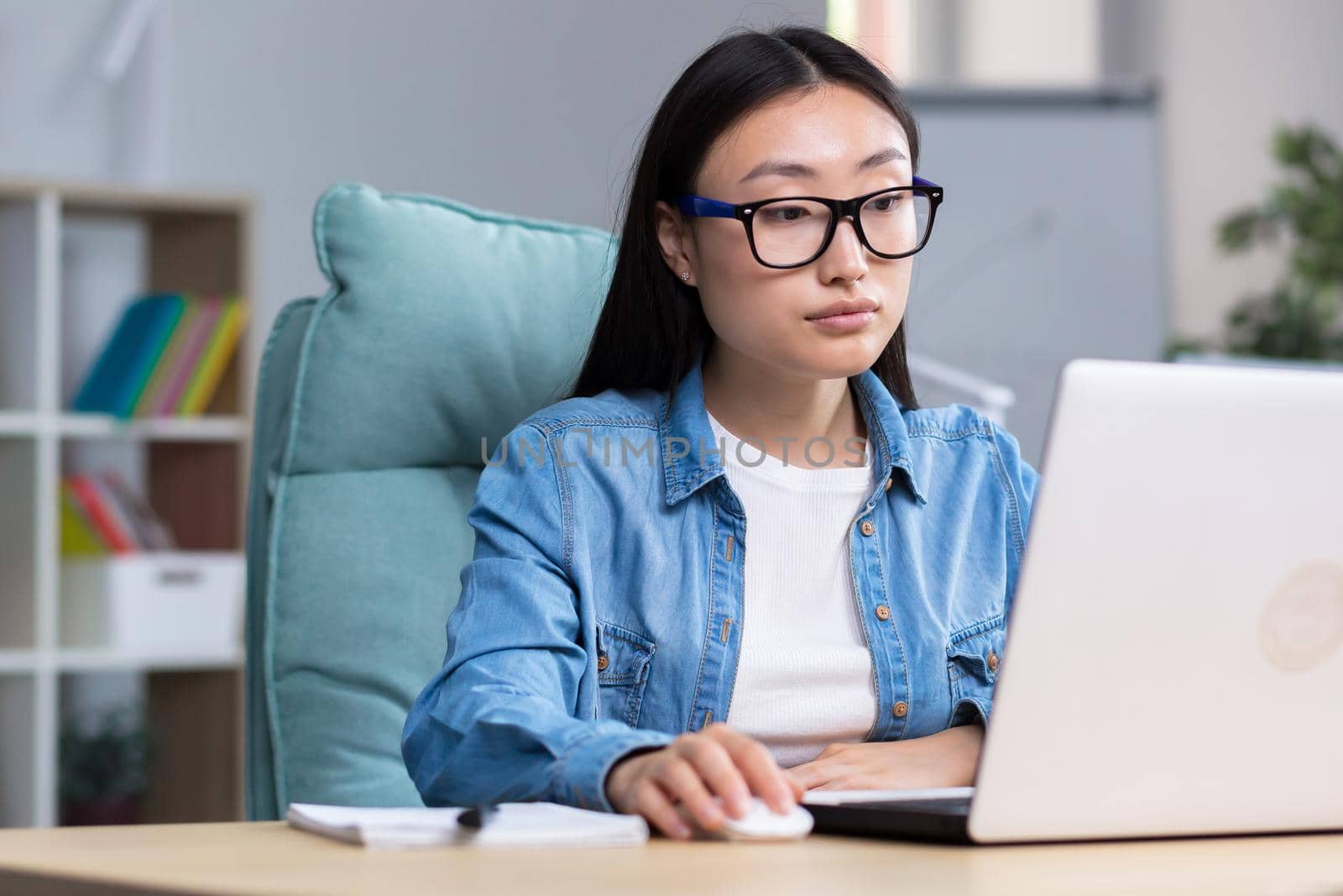 Asian freelancer woman working with laptop in home office remotely, business woman wearing casual clothes.