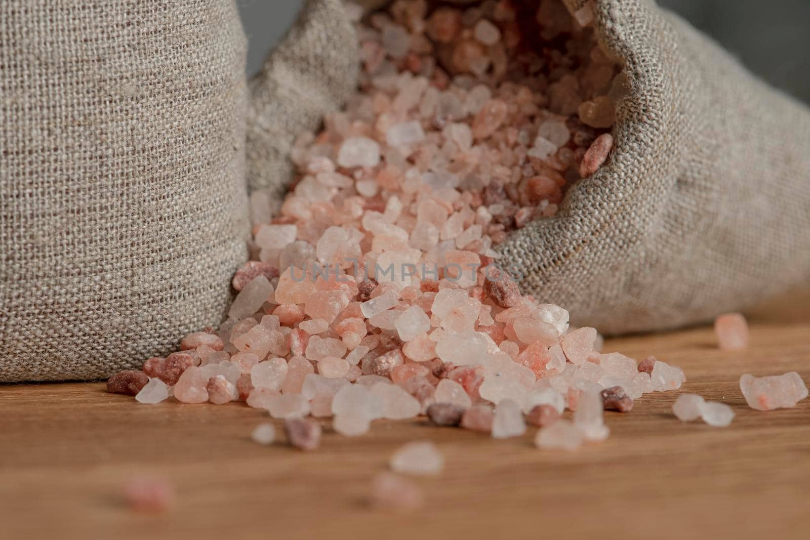 Salt price. Large crystals of pink Himalayan salt, close-up. A coin in a pile of salt as a symbol of rising prices