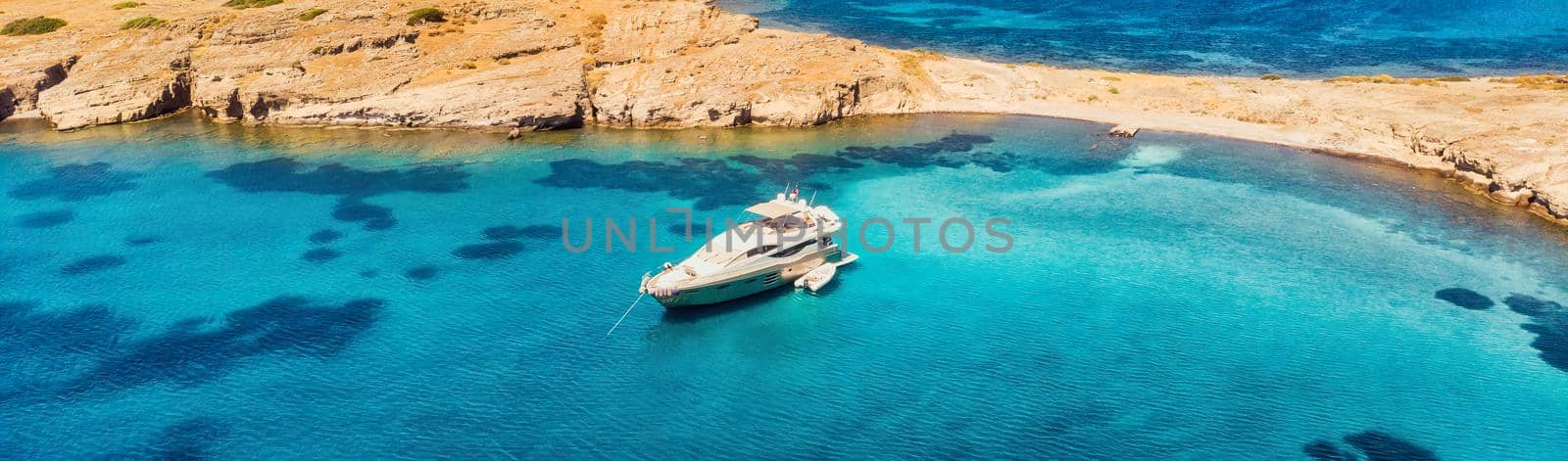 View from above, stunning aerial view of a bay with boat, luxury yacht sailing on a turquoise, clear water.