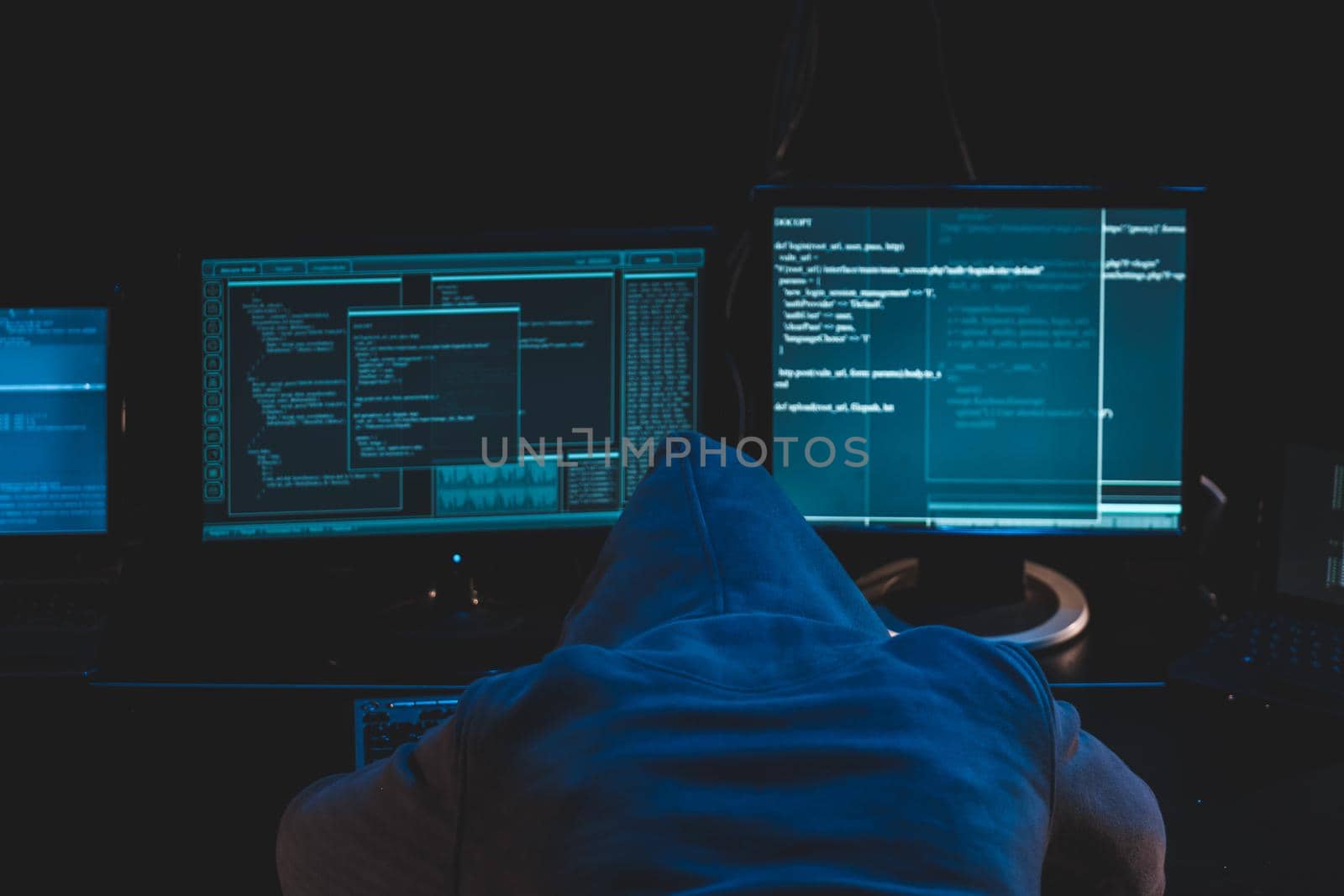 Overworked tired hacker. hooded hacker sleeping at his computer, malicious code software on the screen hacking data center by igor010