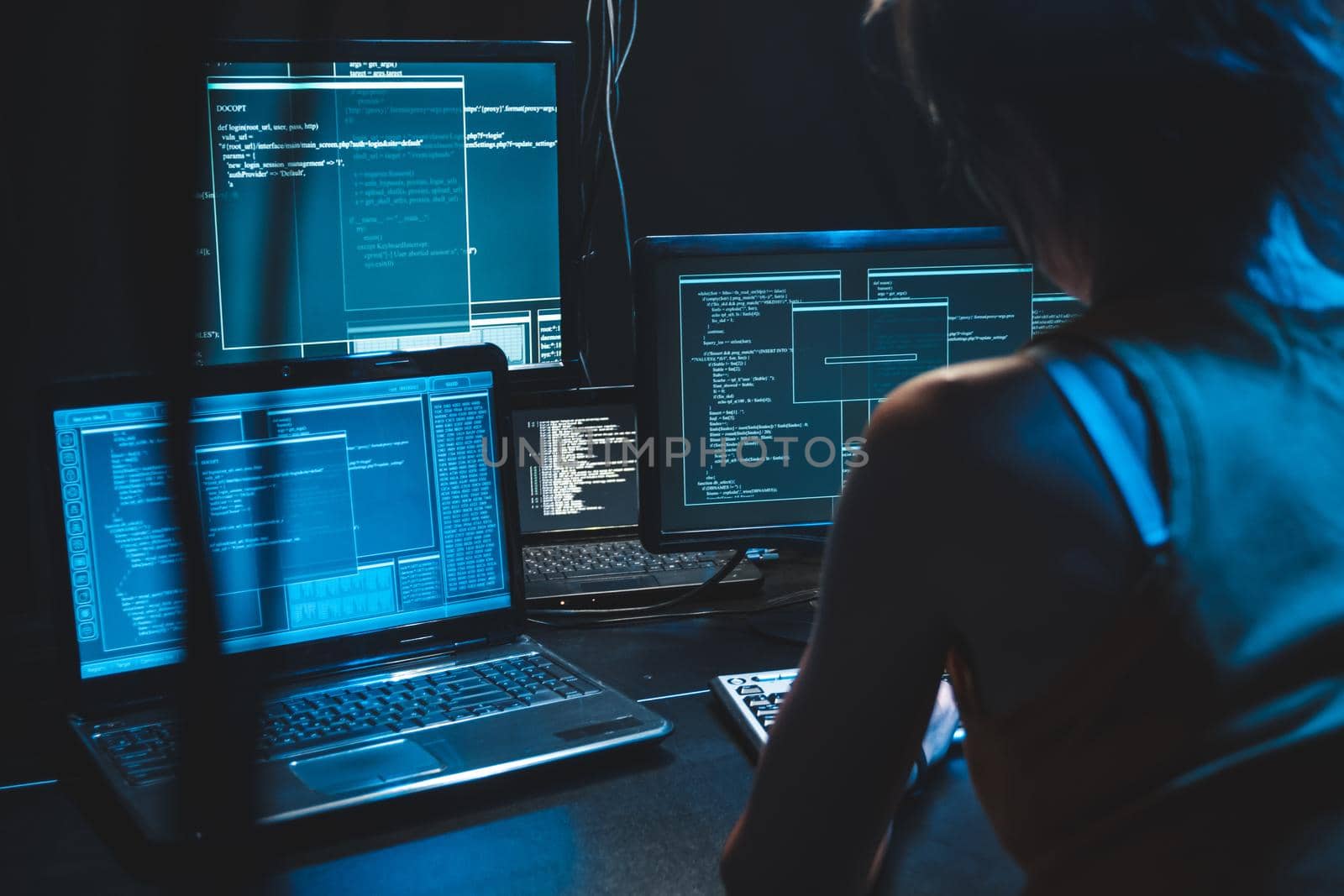 Software developer freelancer woman female  work with program code on wide displays at night Develops new web desktop mobile application. Coder work on software program. Programmer at night