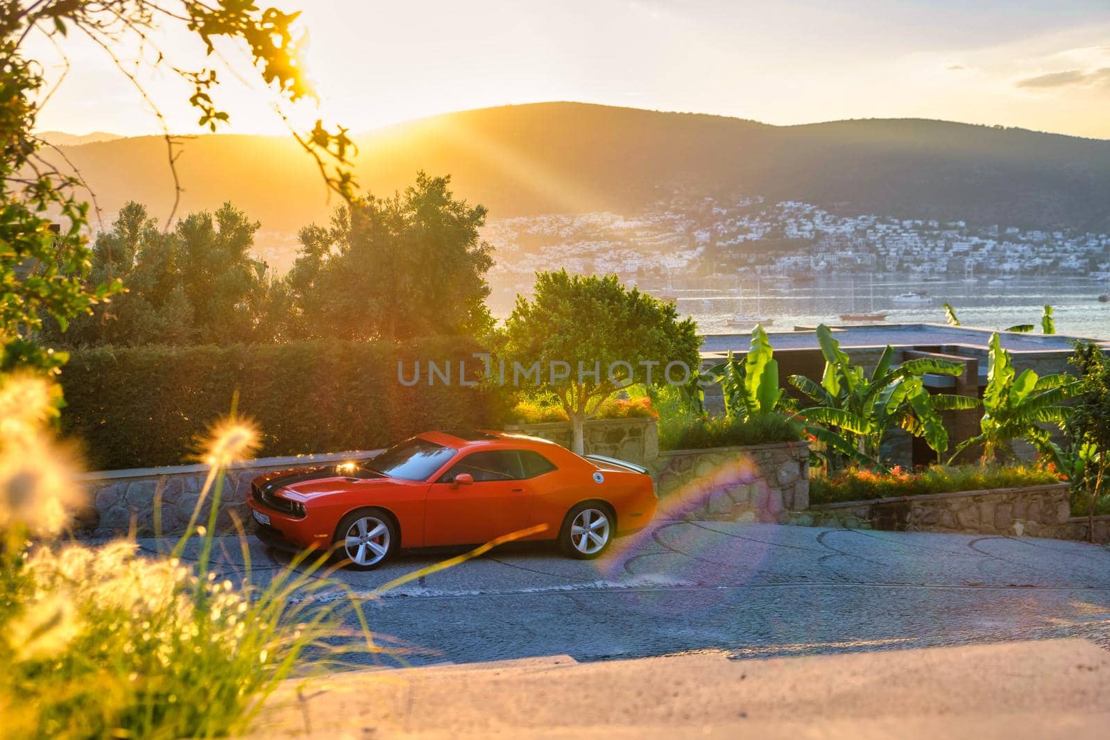 Vintage Sport car parked on road side with golden sunset and mountains on background. car on the road