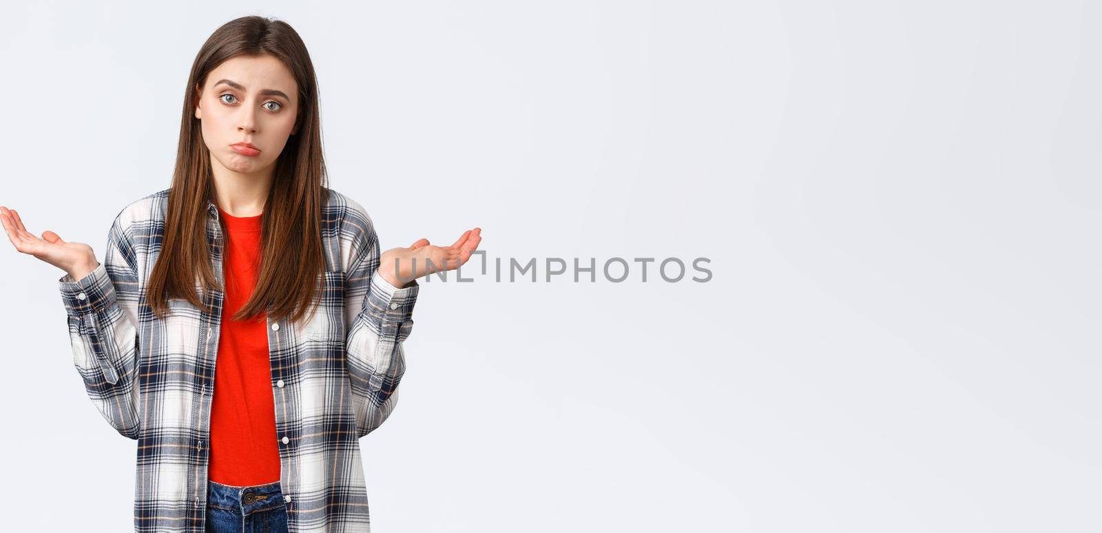 Lifestyle, different emotions, leisure activities concept. Reluctant and careless young woman shrugging with hands spread sideways, dont know, cant help, have no idea, stand white background by Benzoix