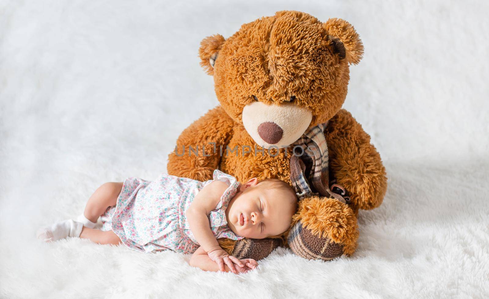 A newborn baby sleeps with a teddy bear. Selective focus. by yanadjana