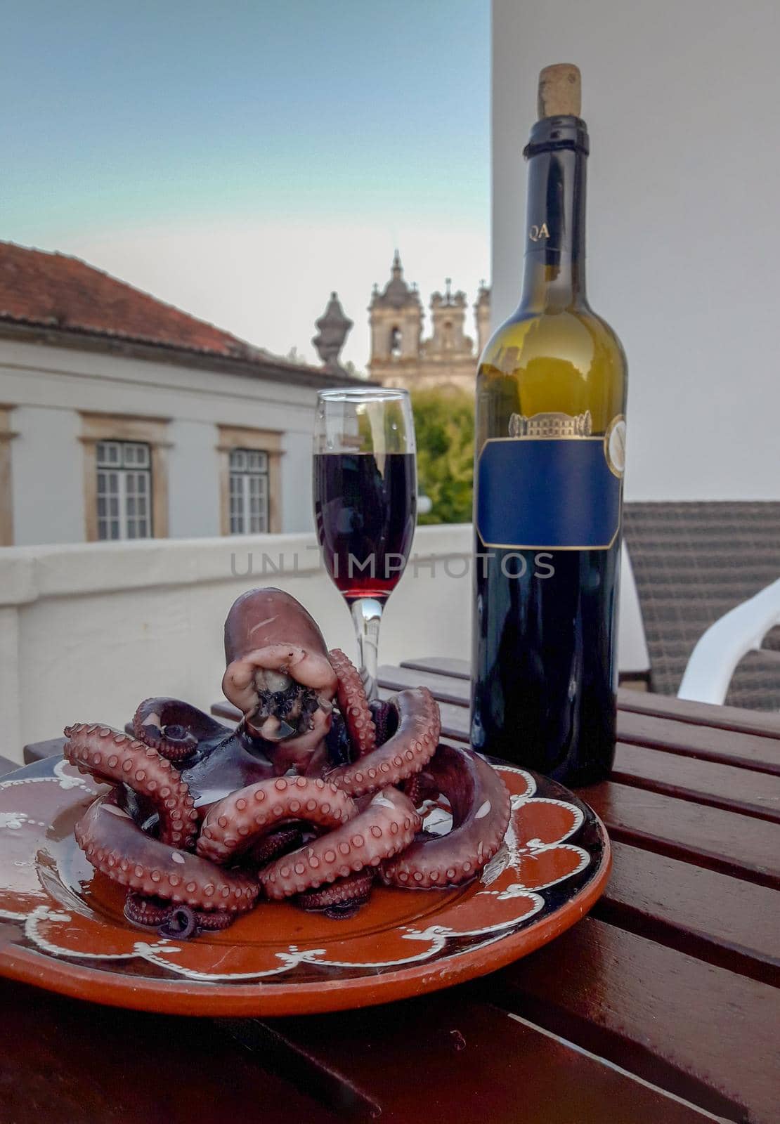 red wine bottle with glass and octopus from the hotel balcony. download photo
