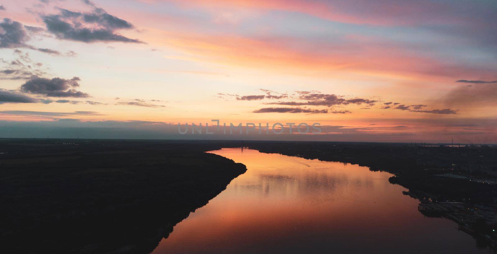 sunset with clouds, light rays over river with reflections. High quality photo