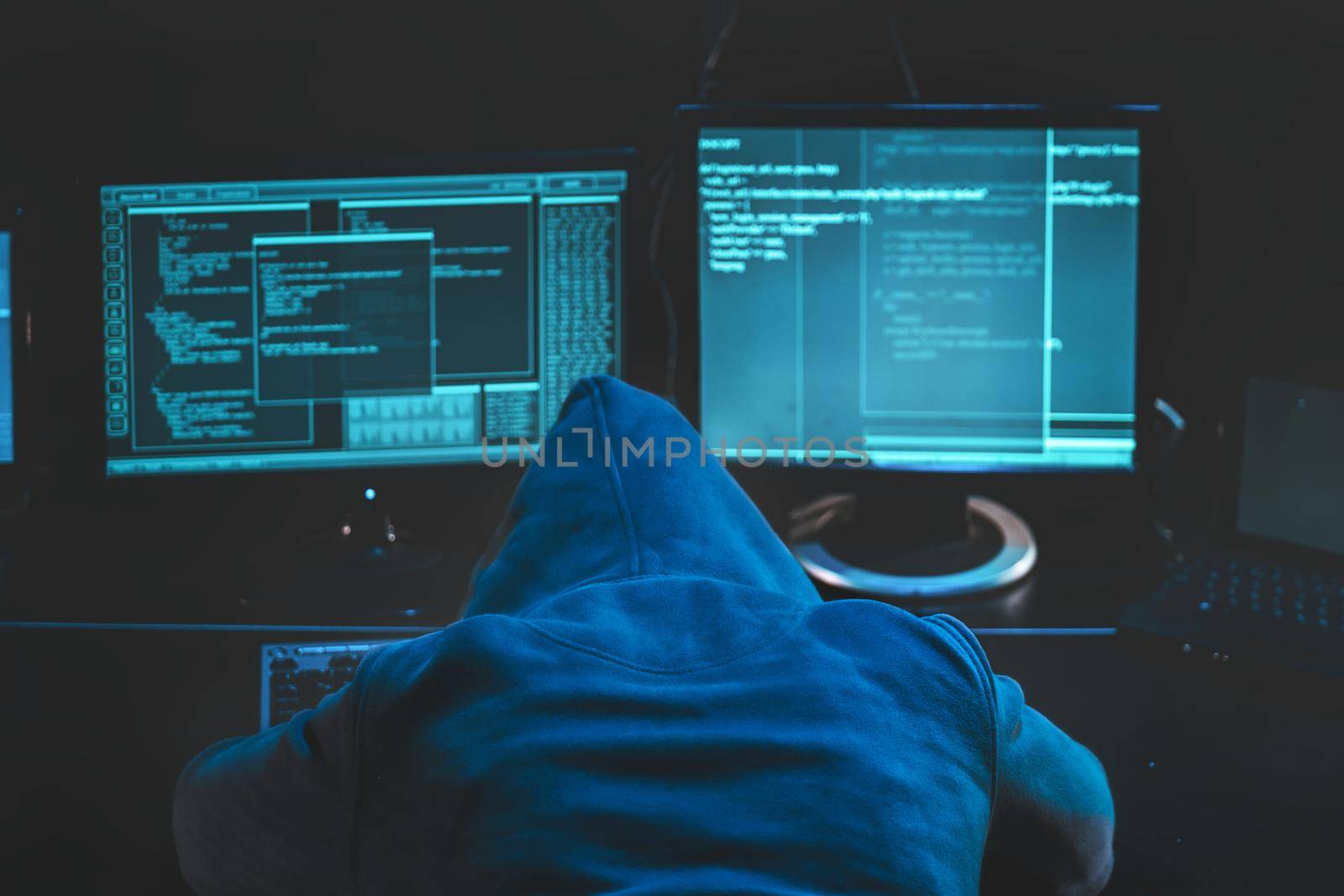 Overworked tired hacker. hooded hacker sleeping at his computer, malicious code software on the screen hacking data center. Download image by igor010