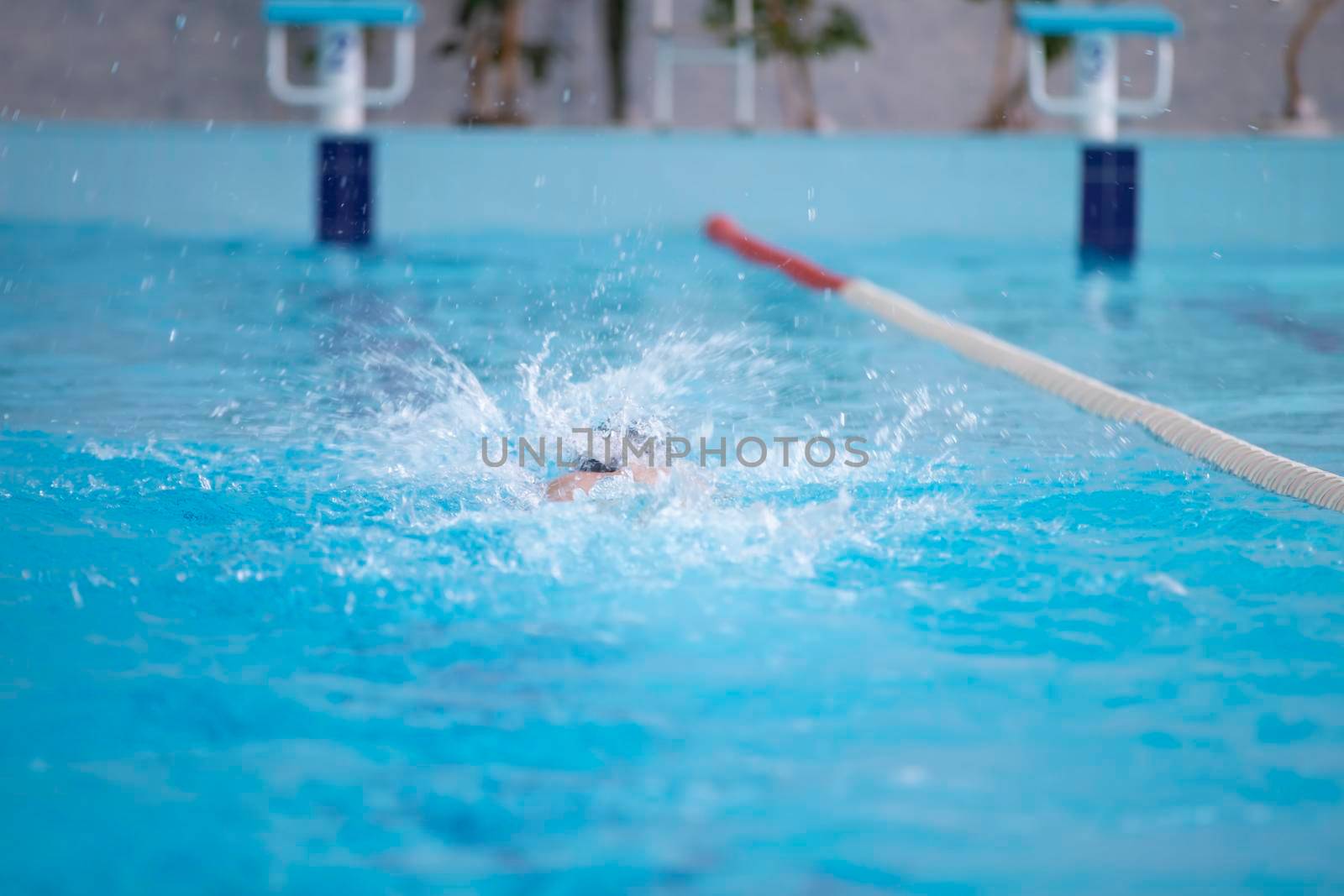 An athlete is swimming in the sports pool.