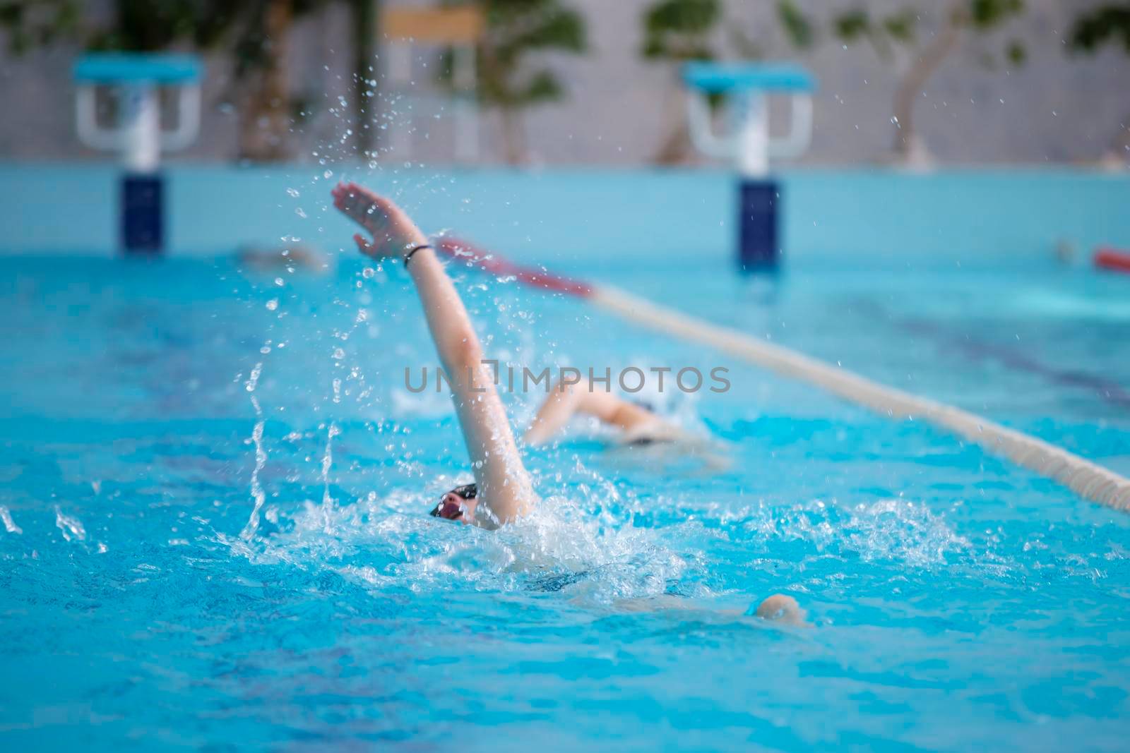 An athlete is swimming in the sports pool.