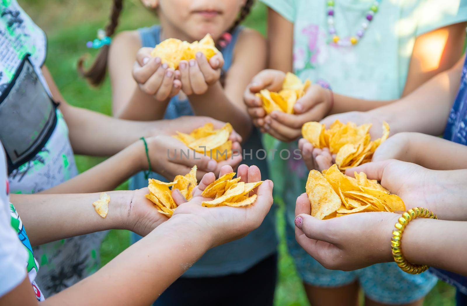 Children are holding chips in their hands. Selective focus. by yanadjana