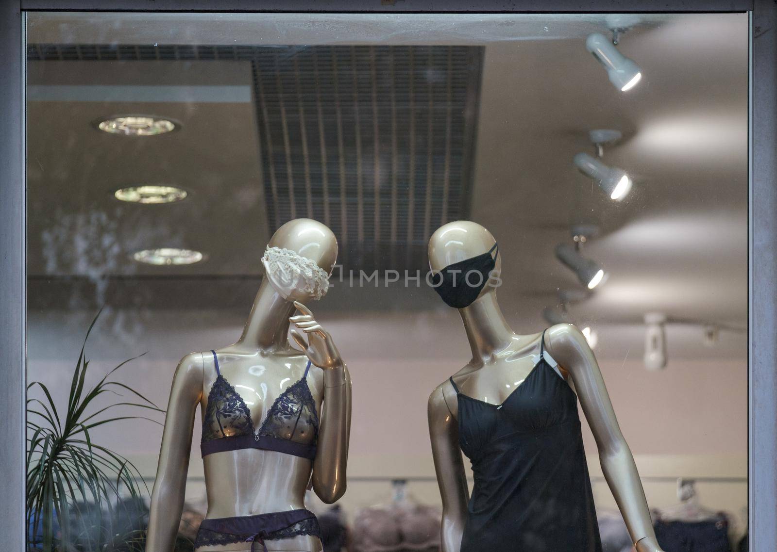 Two female mannequins wear in mask looking on you, underwear dressed. download photo