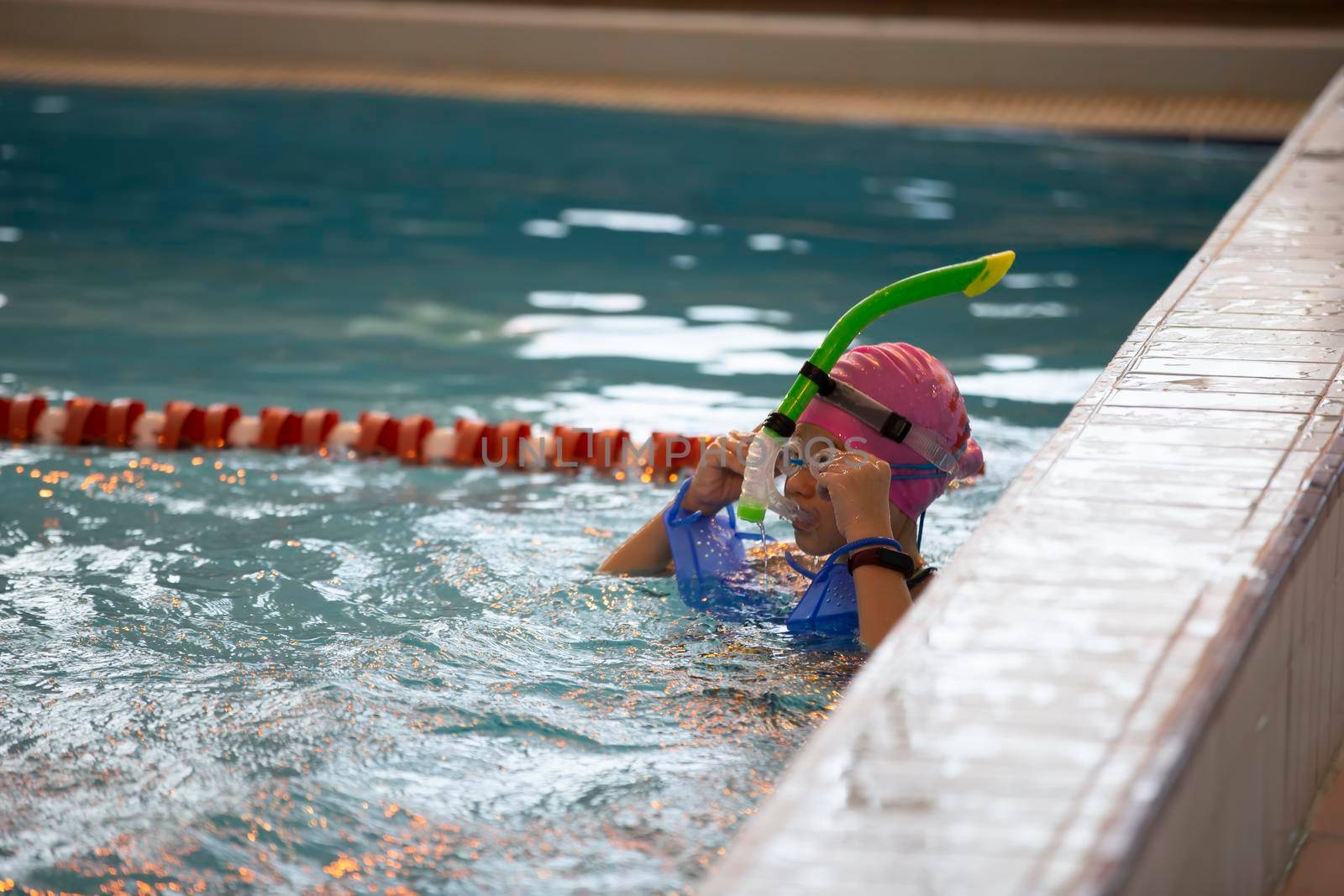 Child athlete swims in the pool. Swimming section.