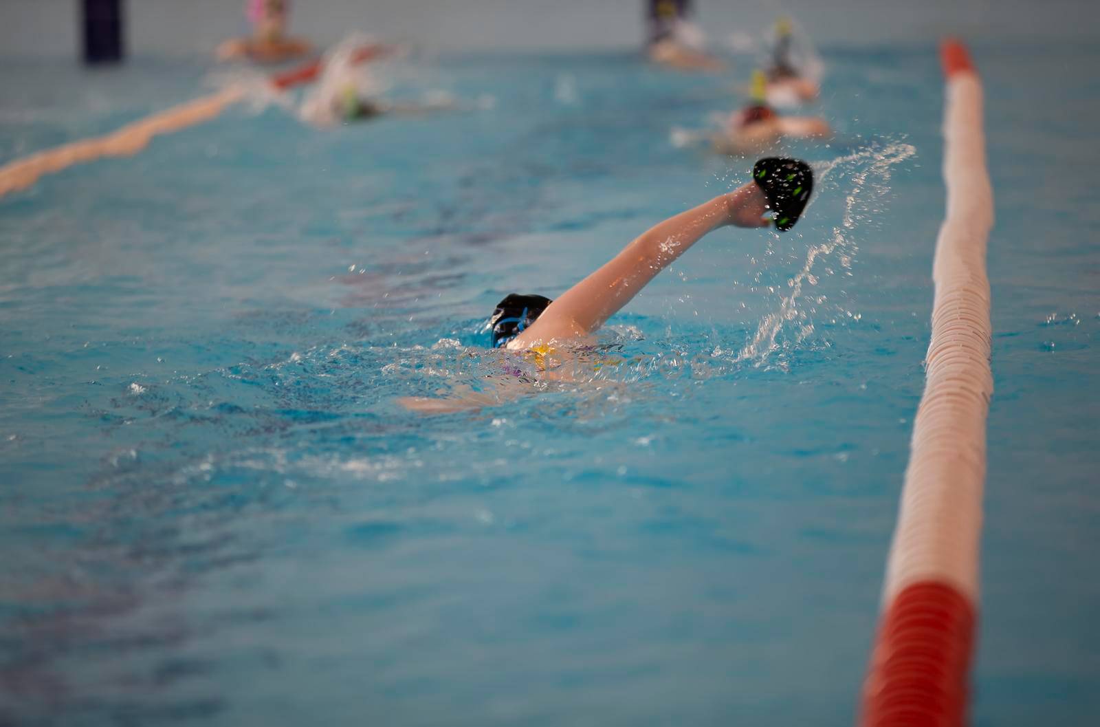 Child athlete swims in the pool. Swimming section.