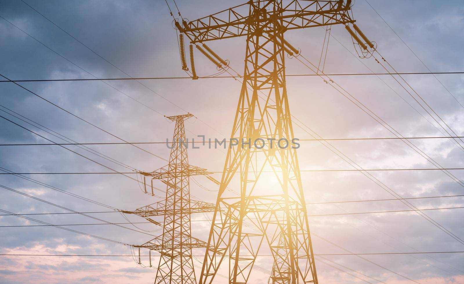 High voltage electric tower line on sky background, Sunset silhouette of pylon.