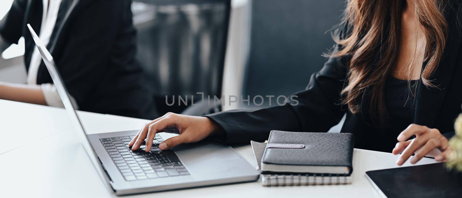 Cropped image of businesswoman using laptop computer at meeting room.