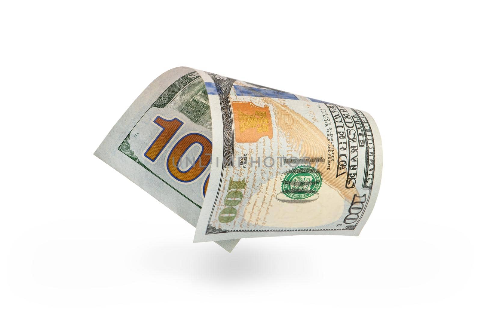 Hundred dollar bill falling casting shadow, half-folded bill close-up on white background.