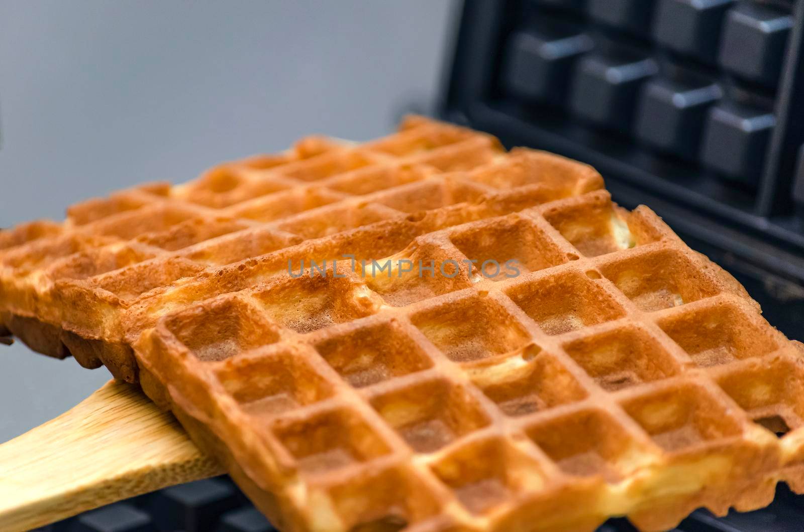 Modern waffle maker with ingredients, homemade Belgian waffles.