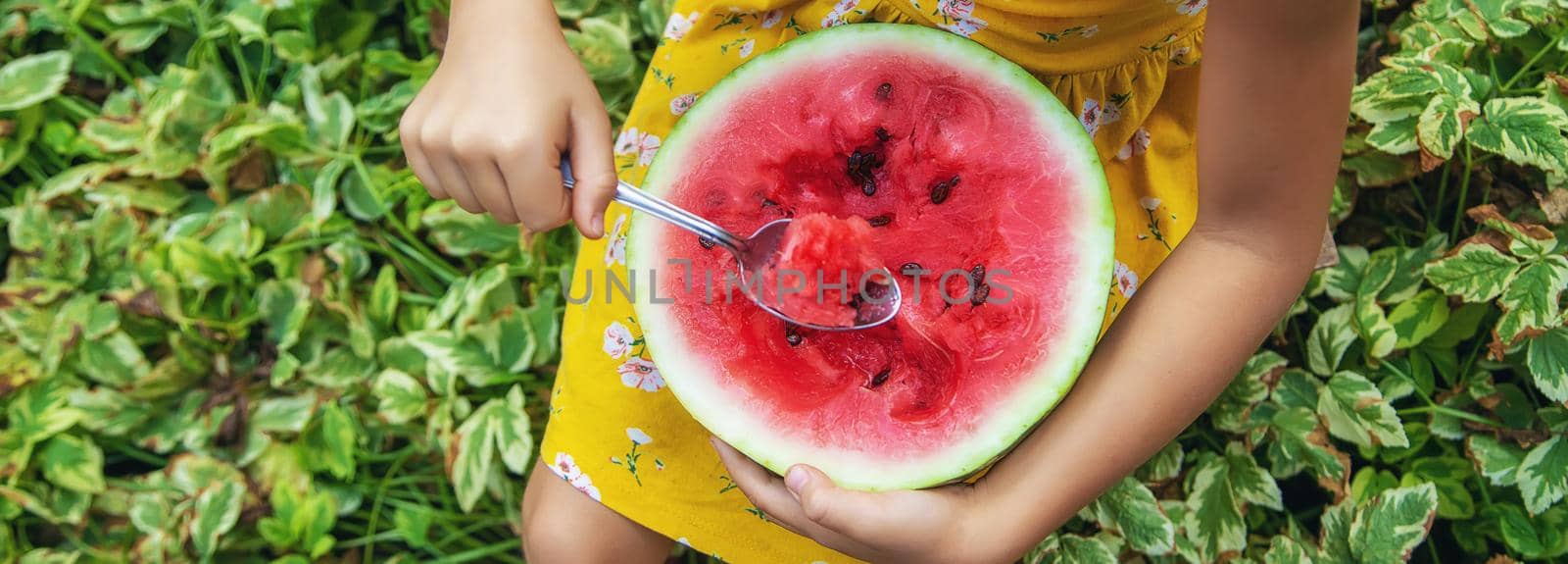 The child eats a watermelon with a spoon. Selective focus. food.