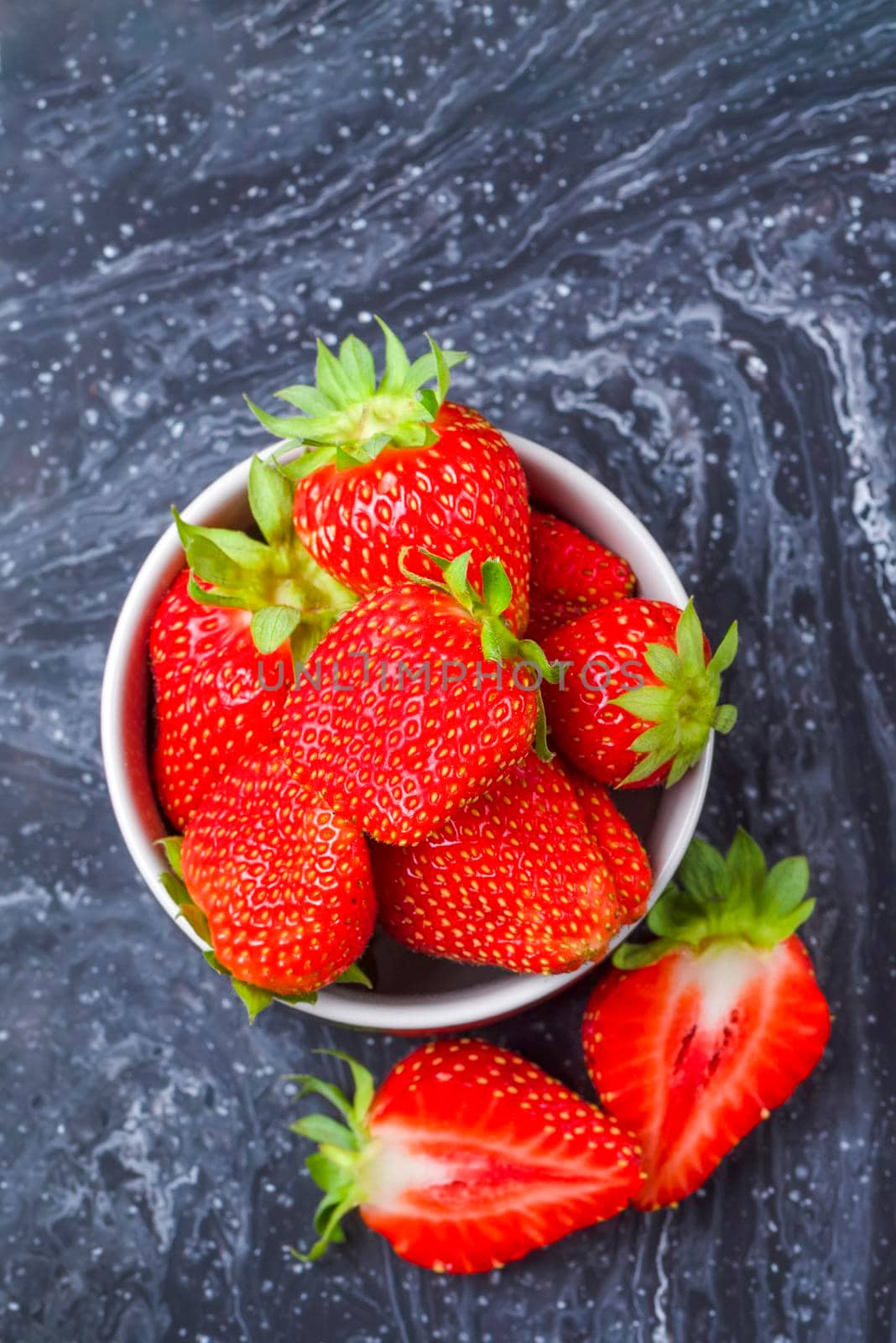 Strawberries on black marble. Ripe strawberries in a saucer on a black background. Place to insert text by SERSOL