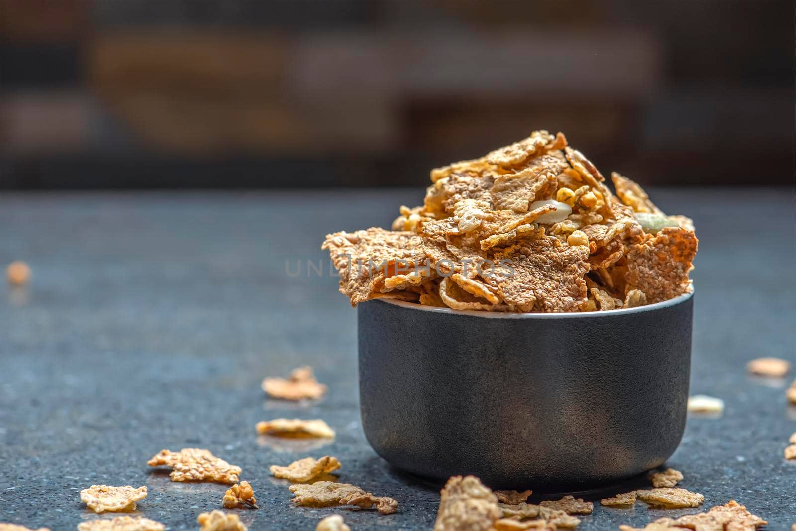 Dry muesli in a saucer on the background of a stone table top. Healthy food and light diet breakfast concept, copy space.
