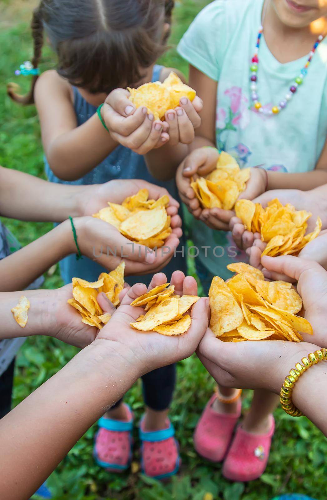 Children are holding chips in their hands. Selective focus. people.