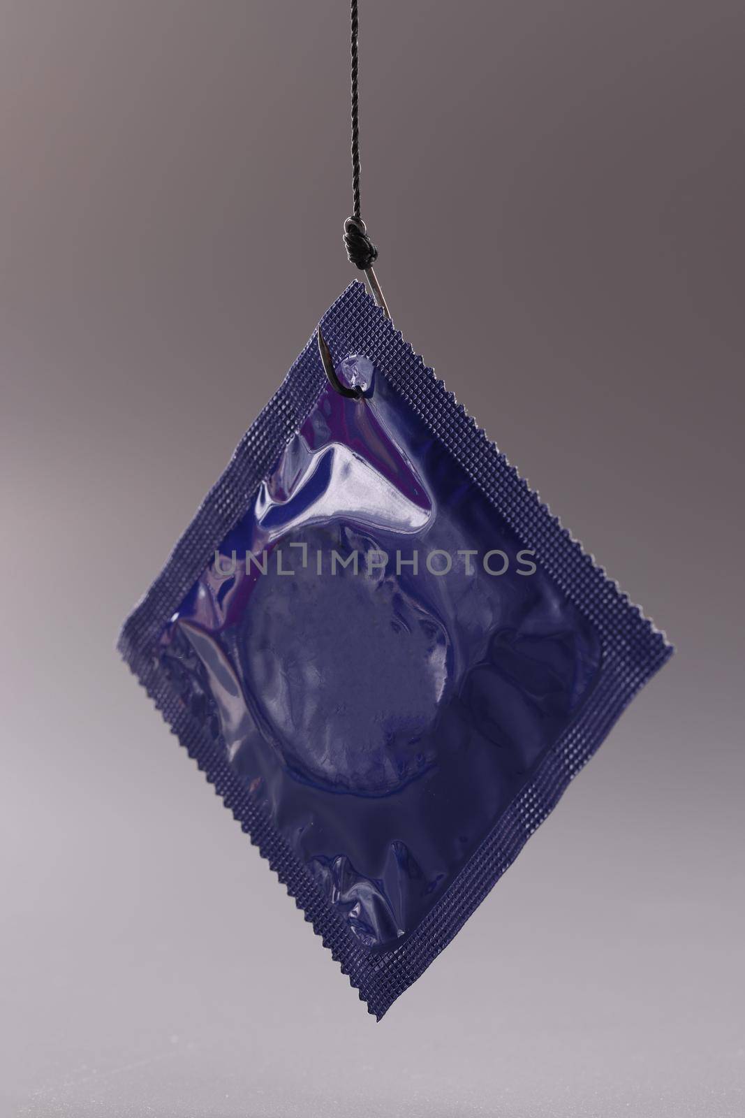 Blue condom packaging on gray background. Safe sex rules concept