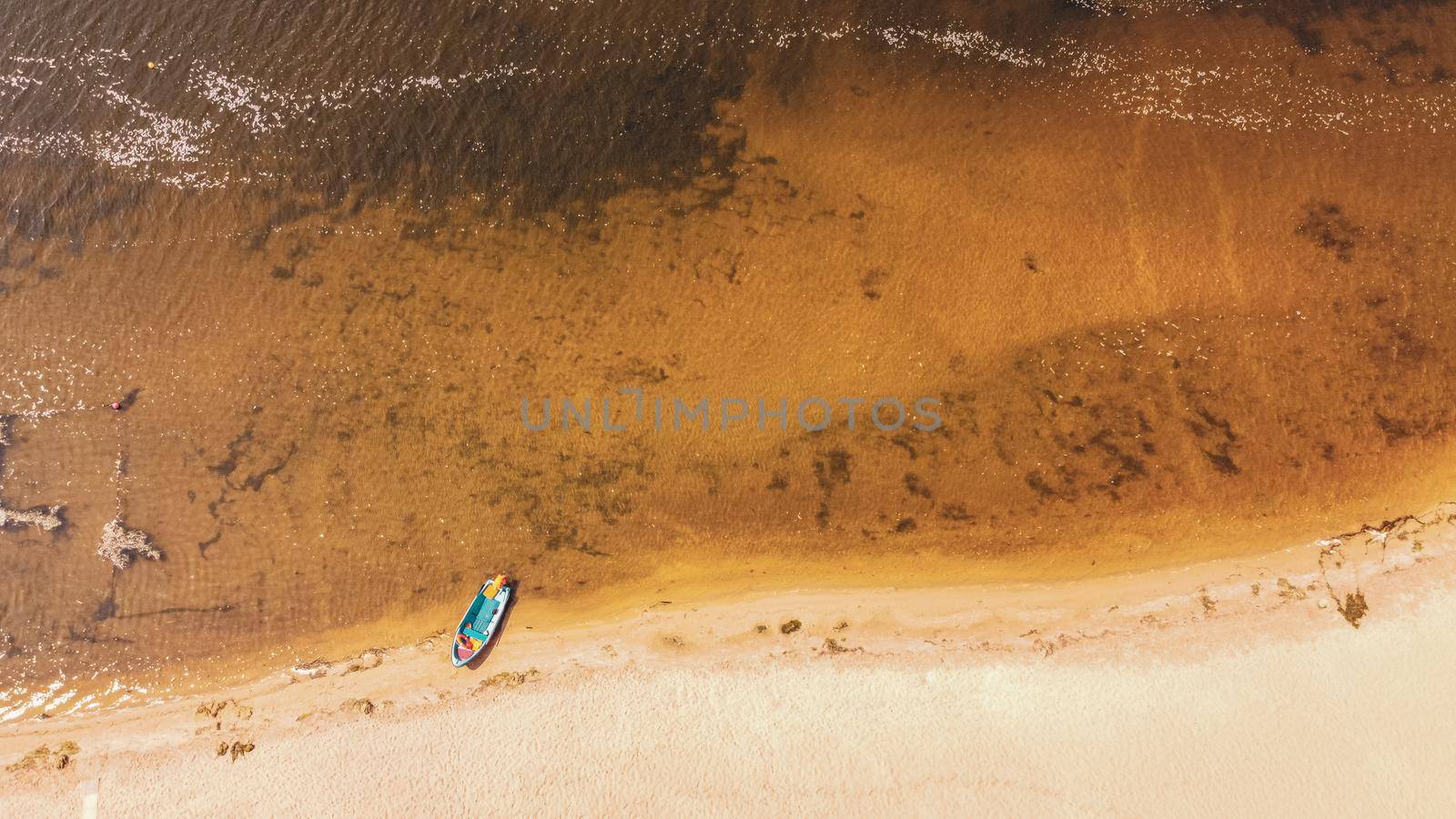 Aerial view on coastline. Summer seascape with clear water in sunny day. Top view of boat from drone. Summer seascape from air. Travel image