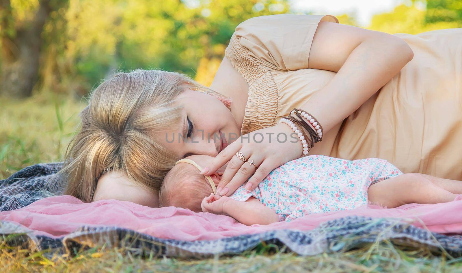 Mom with a newborn baby in her arms. Selective focus. by yanadjana