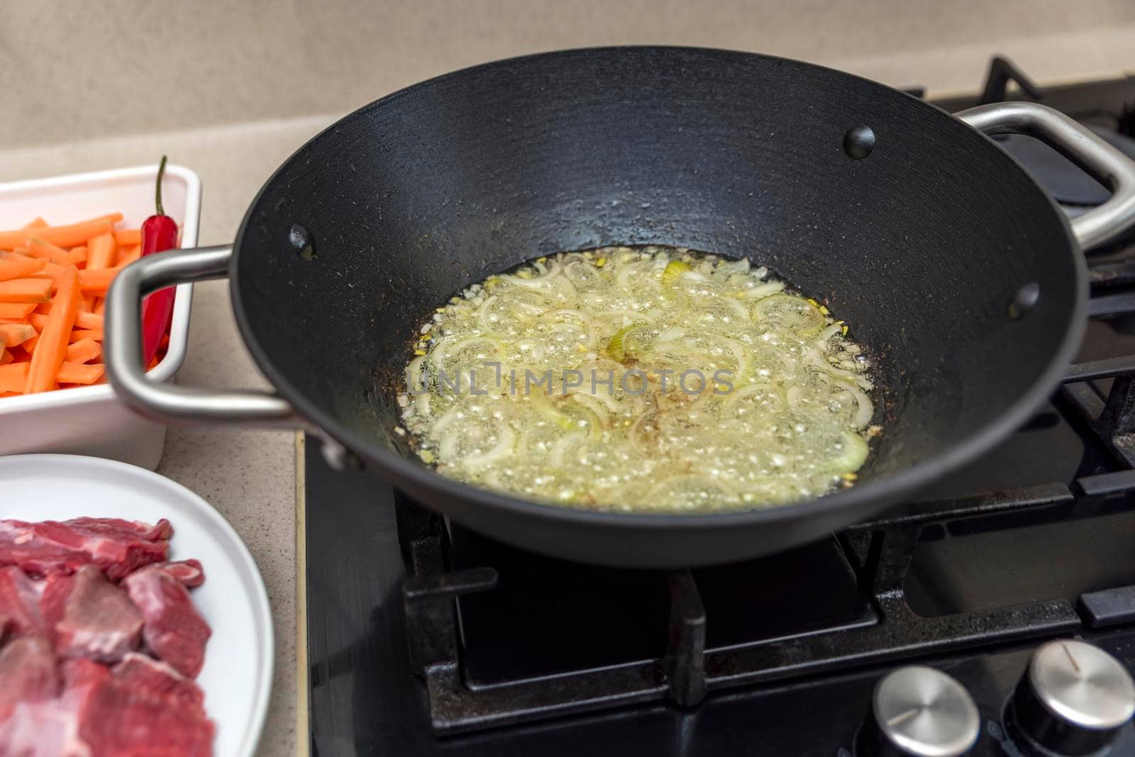 Cooking pilaf in a cauldron, a recipe for real pilaf. Fry onions in a cauldron for cooking pilaf, pour oil into a cauldron, a saucepan, before cooking