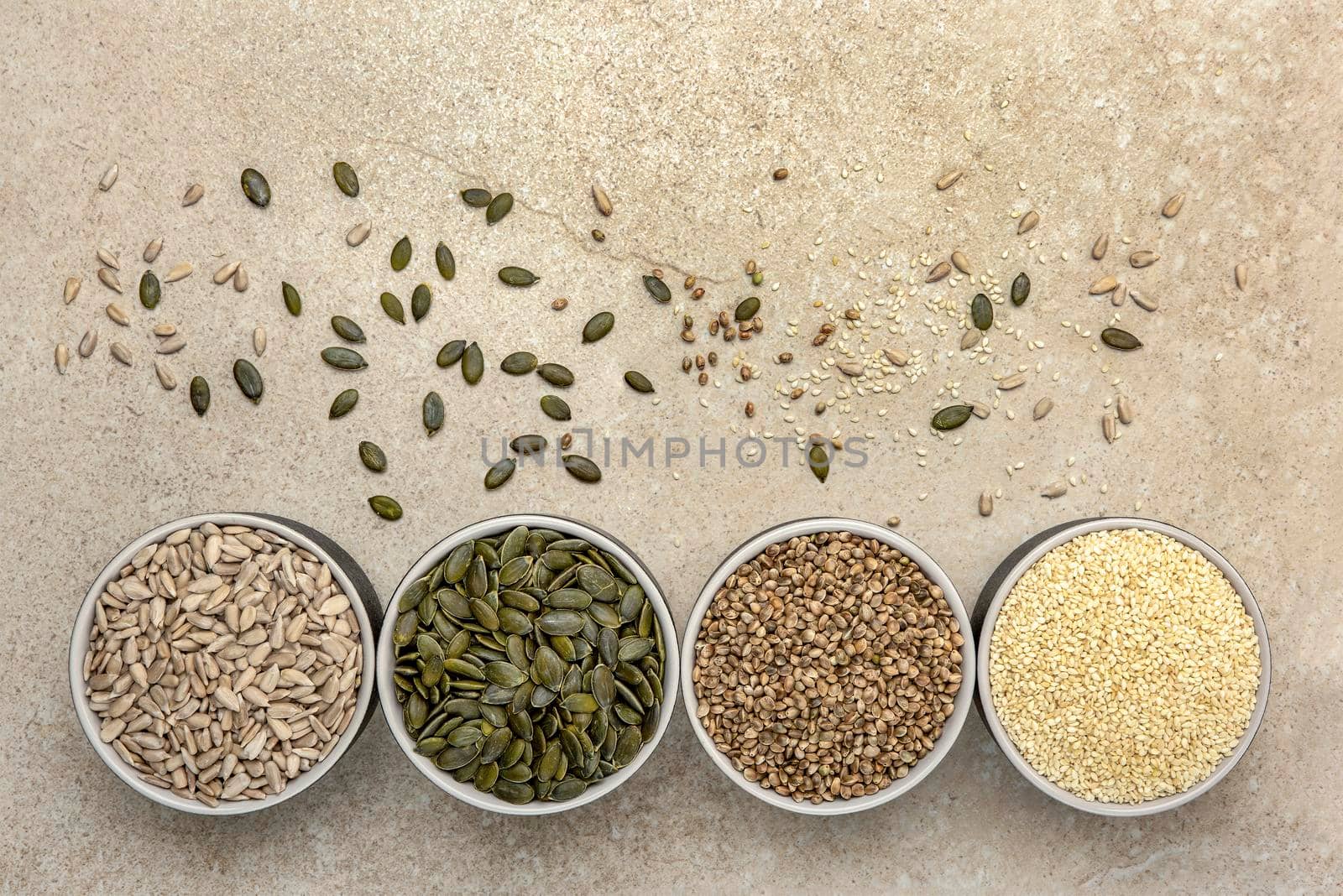 Various seeds on a marble background. Assortment, seeds set, healthy food ingredients, superfoods, copy space. Sunflower, flax, pumpkin, cannabis, poppy seeds