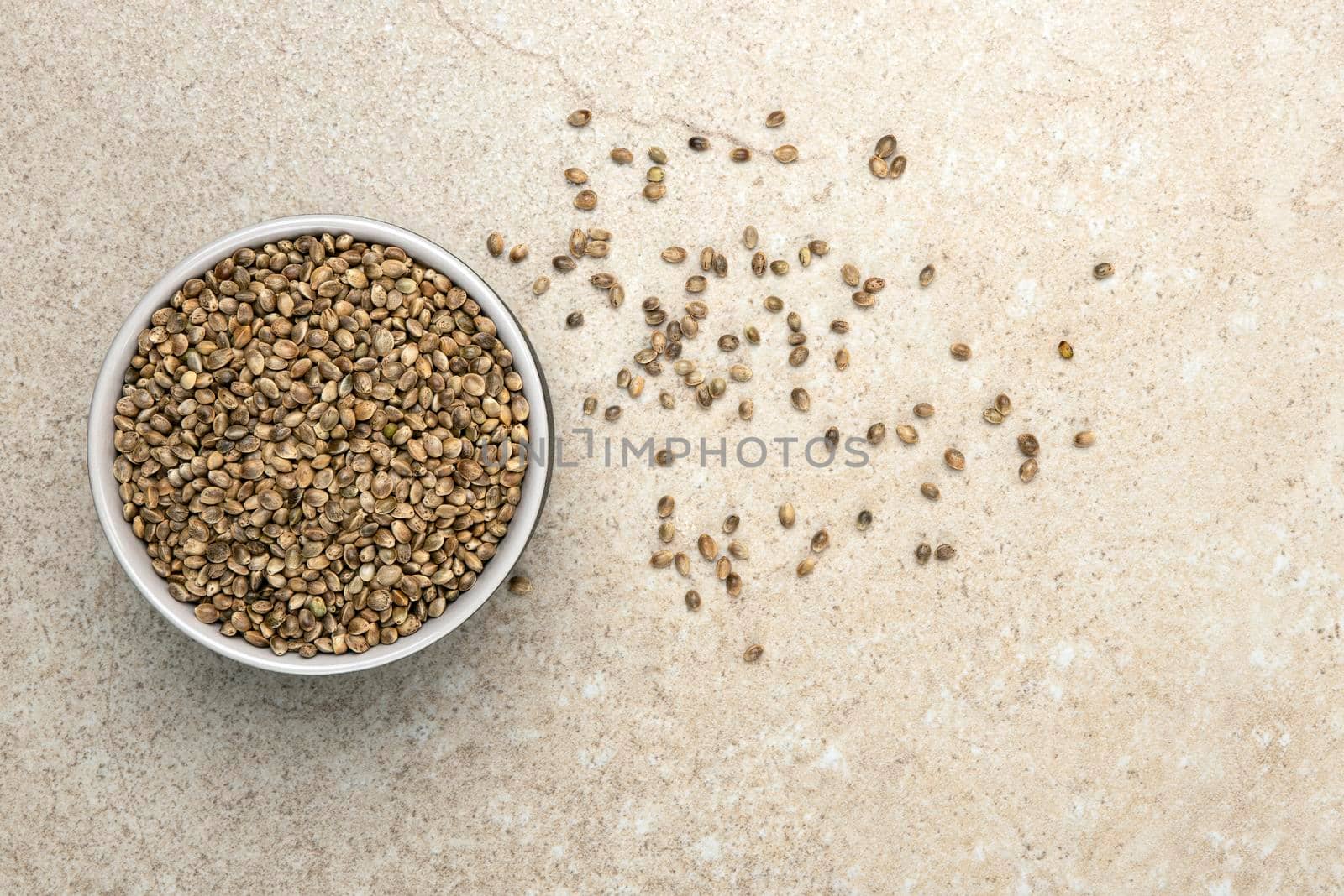 Hemp seeds. Hemp seeds in a cup on a marble table top, top view. Banner on the theme of hemp with place for text.