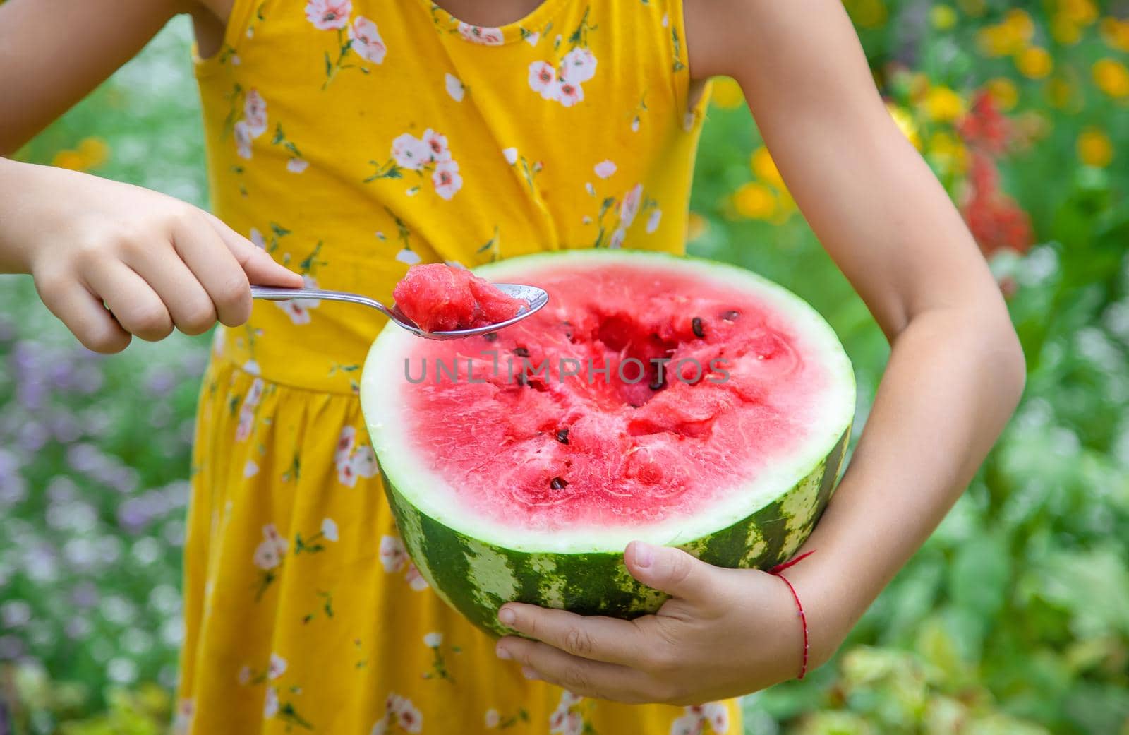 The child eats a watermelon with a spoon. Selective focus. food.