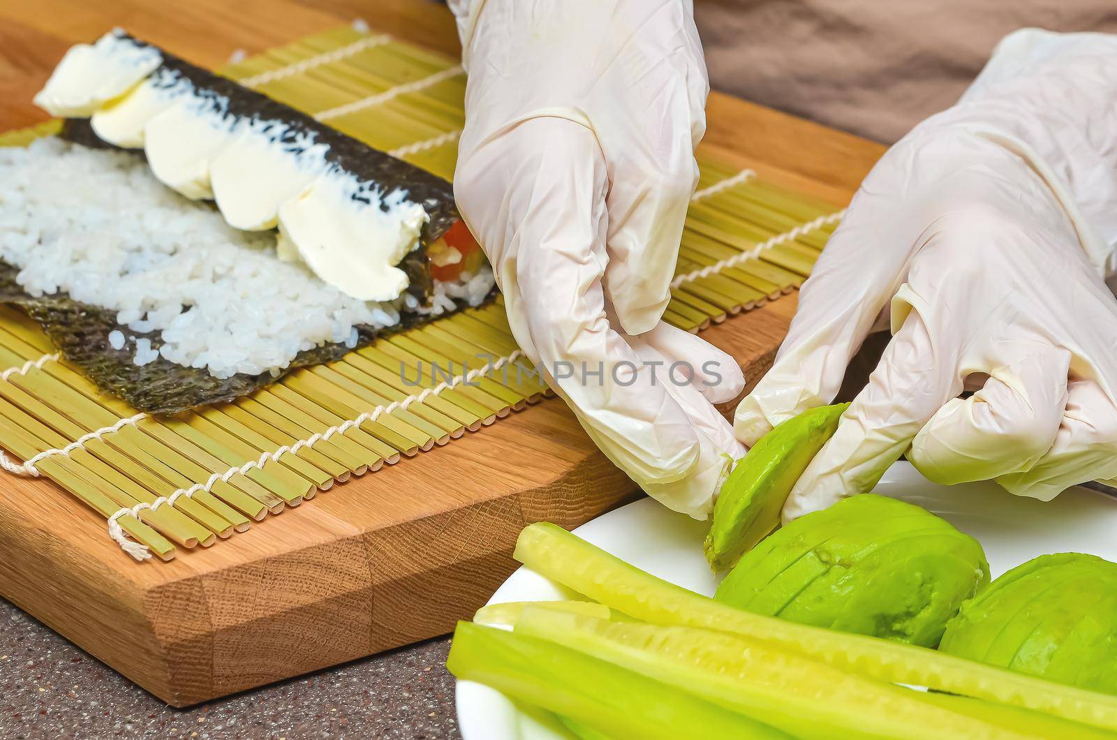 Sushi and rolls preparation process, top view, avocado for Japanese sushi.