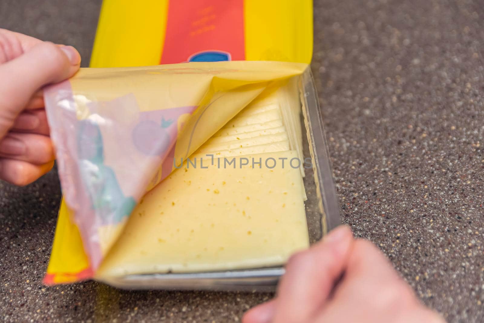 Opens a bag of sliced cheese, a woman opens a bag of cheese, pieces of cheese in a bag, making breakfast