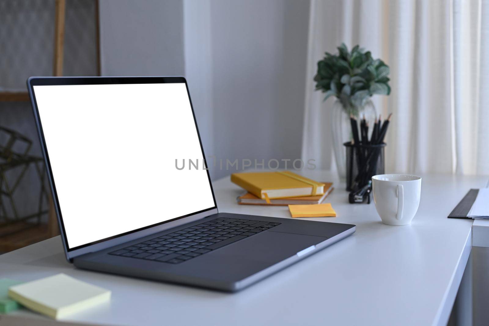 Computer laptop with empty display on white office desk. by prathanchorruangsak